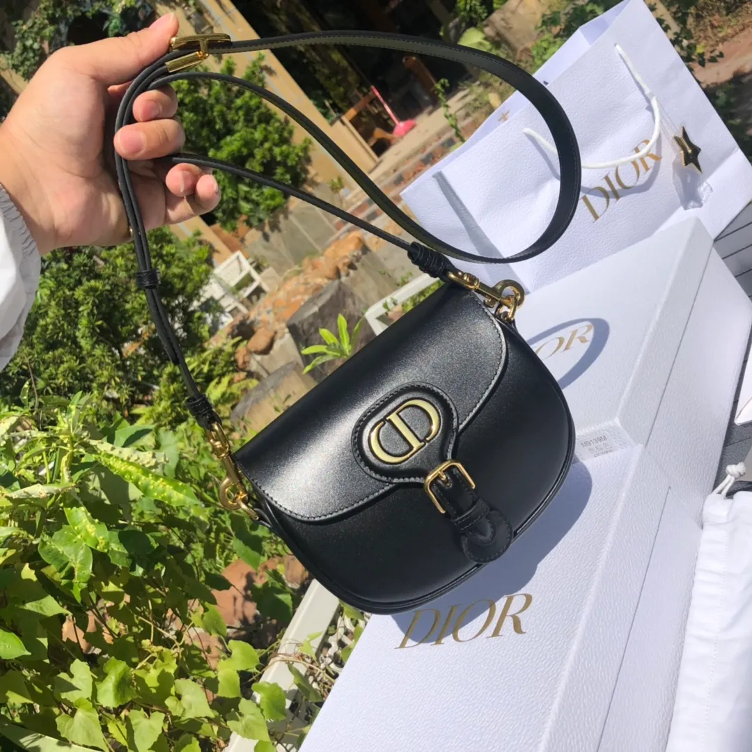 Top upgraded version 💰1700 Small size: 18×14×5cm Dior overseas channels! Dior Saddle Bag😘This Dior Bobby handbag is a shoulder bag style, showing elegant silhouette and coordinated proportions. This small bag is crafted from glossy black calfskin and accented with antiqued gold hardware for added style. The interior is designed with suede leather, which is soft and rich in texture. With a detachable and adjustable shoulder strap embellished with a military-style buckle, it can be worn on the shoulder, cross-body or handheld.