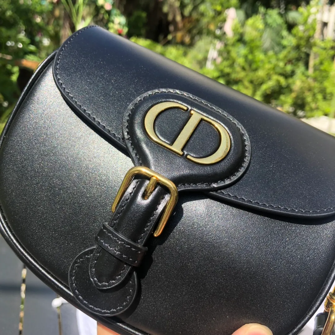 Top upgraded version 💰1700 Small size: 18×14×5cm Dior overseas channels! Dior Saddle Bag😘This Dior Bobby handbag is a shoulder bag style, showing elegant silhouette and coordinated proportions. This small bag is crafted from glossy black calfskin and accented with antiqued gold hardware for added style. The interior is designed with suede leather, which is soft and rich in texture. With a detachable and adjustable shoulder strap embellished with a military-style buckle, it can be worn on the shoulder, cross-body or handheld.