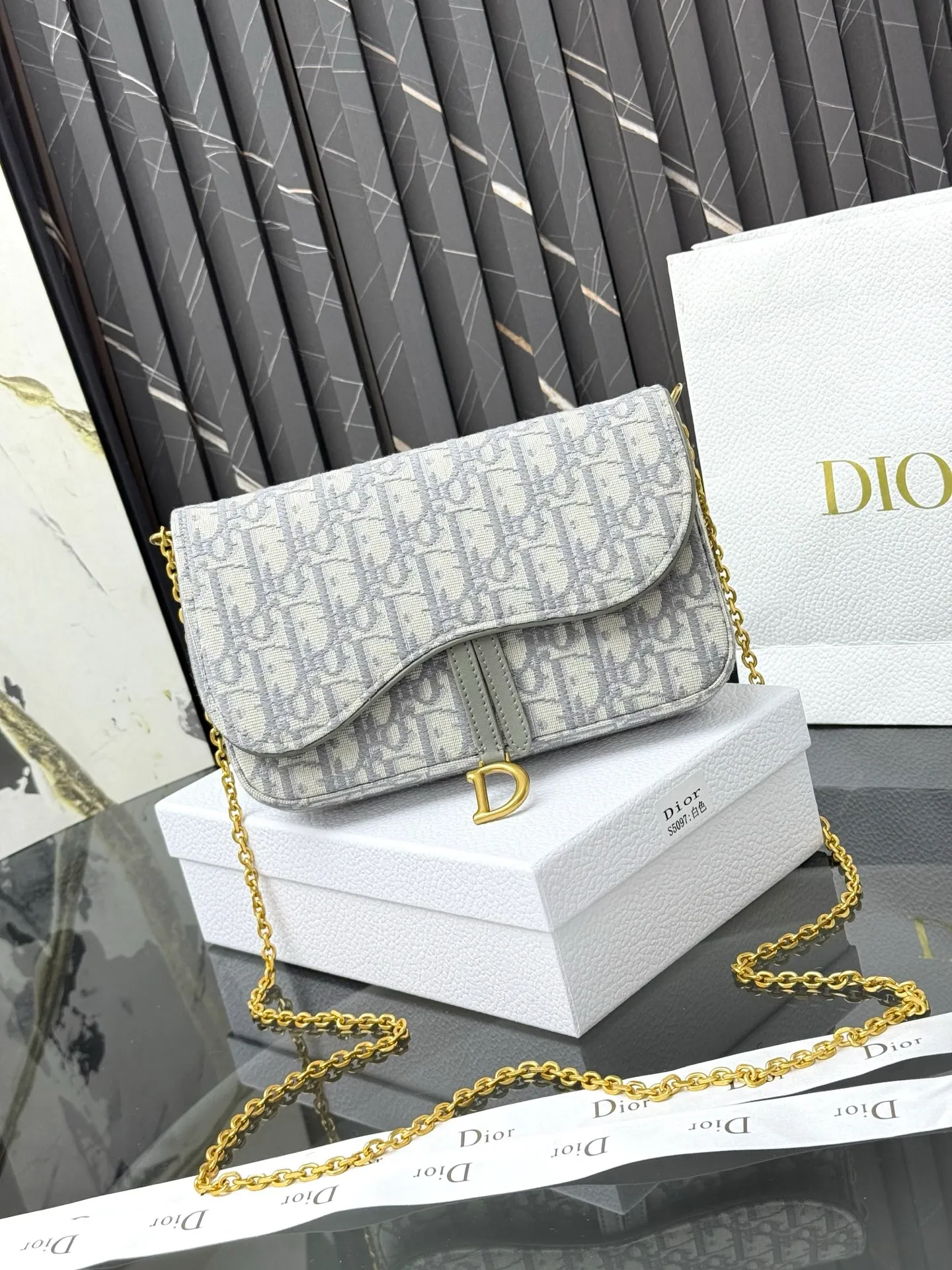 💰290💰 This saddle chain handbag has smooth and coordinated lines, making it a fashionable and practical item. Carefully crafted from blue Denim Dior Oblique jacquard fabric, the classic Dior pattern is reinterpreted with an irregular stonewash effect to highlight the fashionable style. It is paired with an asymmetric flap and a metal stirrup D-shaped pendant with antique gold finish. The spacious interior compartments can store a variety of daily essentials, and the chain makes it easy to carry on the shoulder or cross-body. Easily combines with other pieces from the saddle collection. Flap closure No.: S5907CTZQ_M928 Front stirrup D-shaped charm 1 compartment 6 card slots 1 slip pocket - No.: S5097 Dimensions: 21.5x12.5x3.7 cm (LxHxW) Can store 1 mobile phone, 1 card holder and lipstick Chain length: 118 cm Length from the top of the chain to the top of the bag: 57 cm