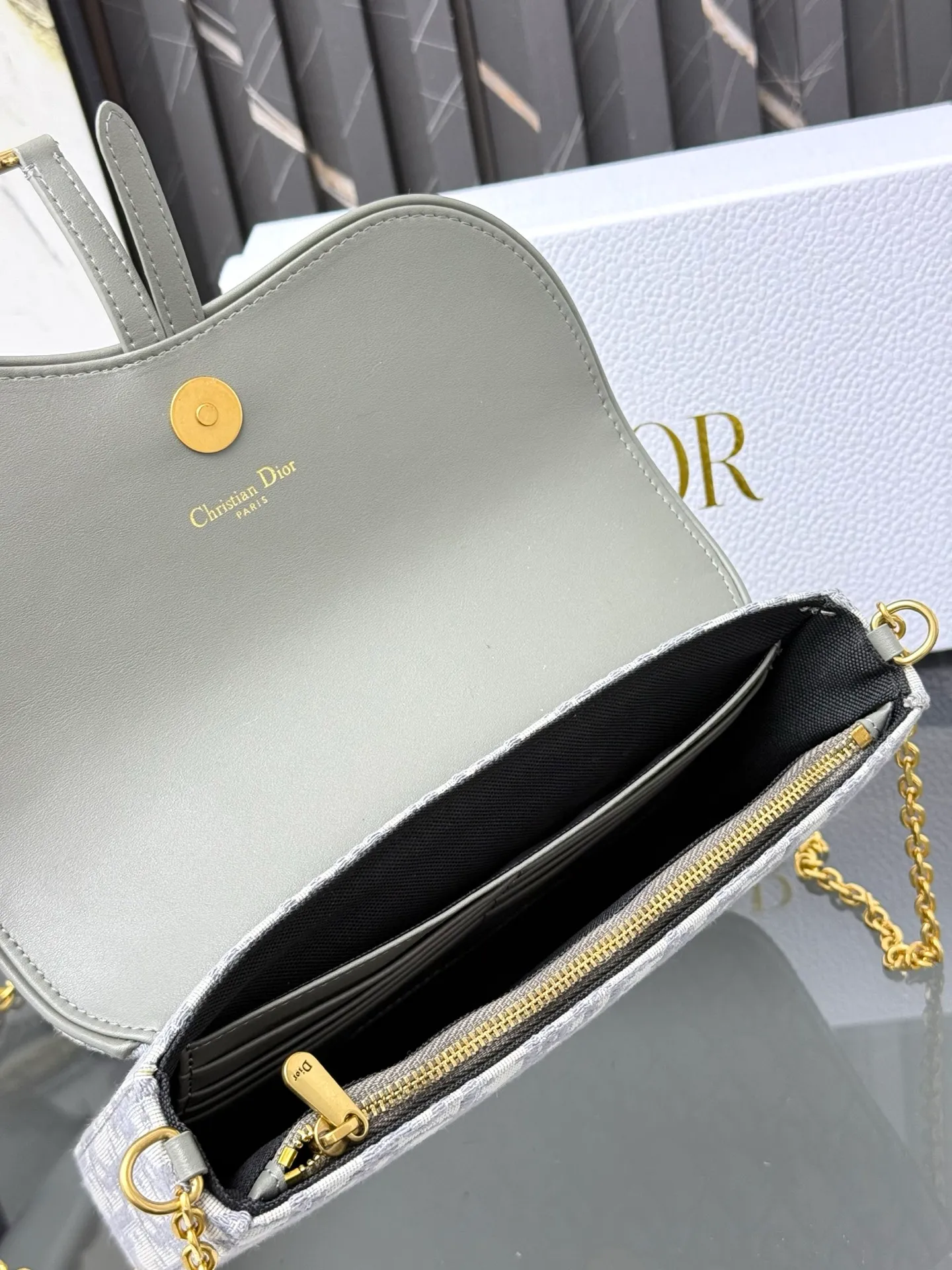 💰290💰 This saddle chain handbag has smooth and coordinated lines, making it a fashionable and practical item. Carefully crafted from blue Denim Dior Oblique jacquard fabric, the classic Dior pattern is reinterpreted with an irregular stonewash effect to highlight the fashionable style. It is paired with an asymmetric flap and a metal stirrup D-shaped pendant with antique gold finish. The spacious interior compartments can store a variety of daily essentials, and the chain makes it easy to carry on the shoulder or cross-body. Easily combines with other pieces from the saddle collection. Flap closure No.: S5907CTZQ_M928 Front stirrup D-shaped charm 1 compartment 6 card slots 1 slip pocket - No.: S5097 Dimensions: 21.5x12.5x3.7 cm (LxHxW) Can store 1 mobile phone, 1 card holder and lipstick Chain length: 118 cm Length from the top of the chain to the top of the bag: 57 cm