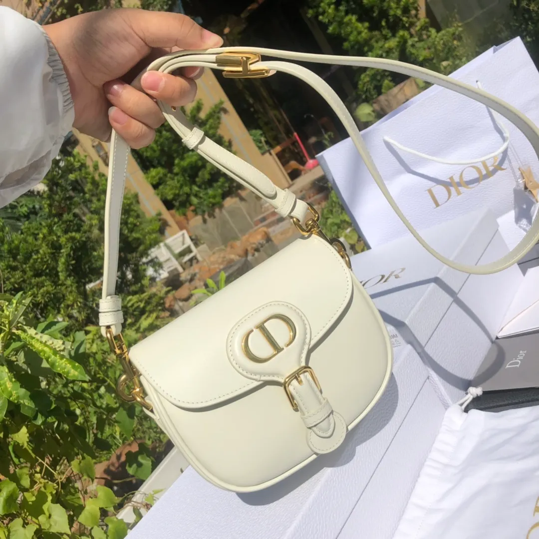 Top upgraded version 💰1700 Small size: 18×14×5cm Dior overseas channels! Dior Saddle Bag😘This Dior Bobby handbag is a shoulder bag style, showing elegant silhouette and coordinated proportions. This small bag is crafted from white glossy calfskin and accented with antiqued gold hardware for added style. The interior is designed with suede leather, which is soft and rich in texture. With a detachable and adjustable shoulder strap embellished with a military-style buckle, it can be worn on the shoulder, cross-body or handheld.