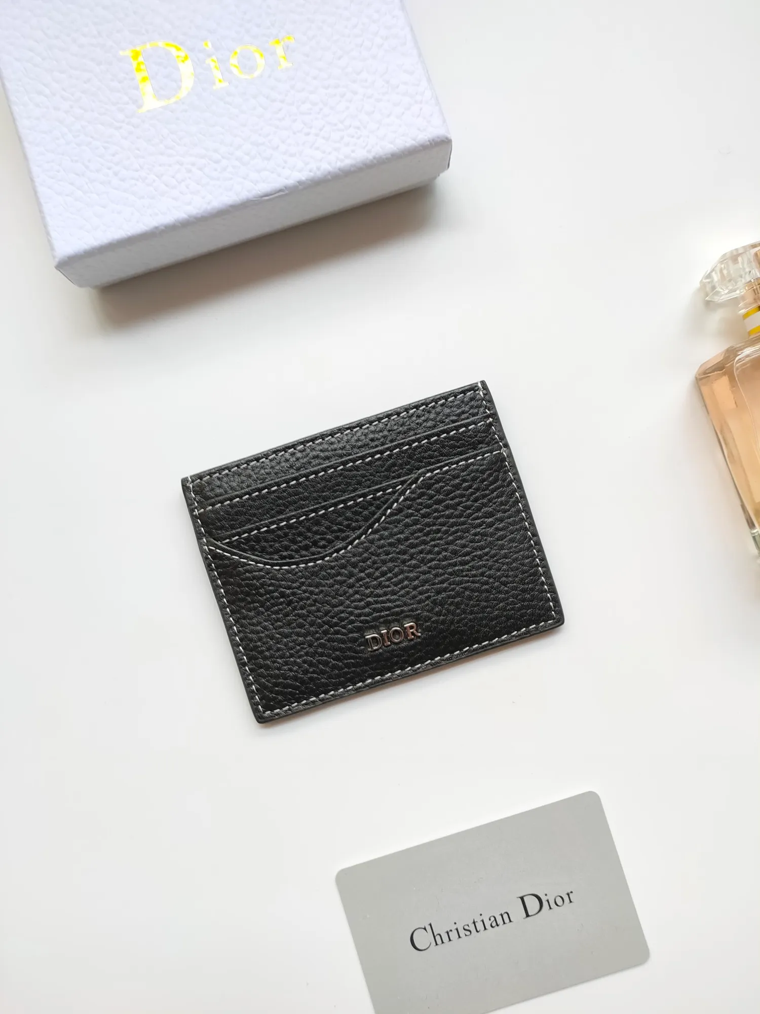 ￥90😍Dior’s new saddle card holder is an elegant accessory that showcases Dior’s exquisite craftsmanship. Style number: CH164 is carefully made of black grained cow leather and decorated with contrasting topstitching, highlighting the classic silhouette of the saddle series. There are three card slots on both sides and a card slot on the top to store various personal items. Elegantly styled with a metal-clad brass Dior signature on the front, it fits easily into any pocket. Size:10*8cm