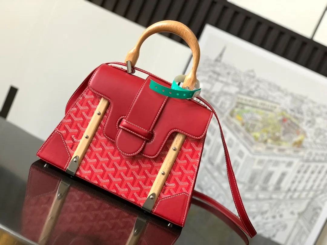 The P1700 original Saïgon bag is one of the signature pieces of the House of Goyard, embodying all the characteristic elements of the brand's boxmaking craftsmanship, such as wood, strips, leather corners and box-making nails. The Saigon Small Bag features a structured design and a removable shoulder strap for a chic and elegant look.  20 cm x 12 cm x 28 cm 🔎LAR 020186-Big Red