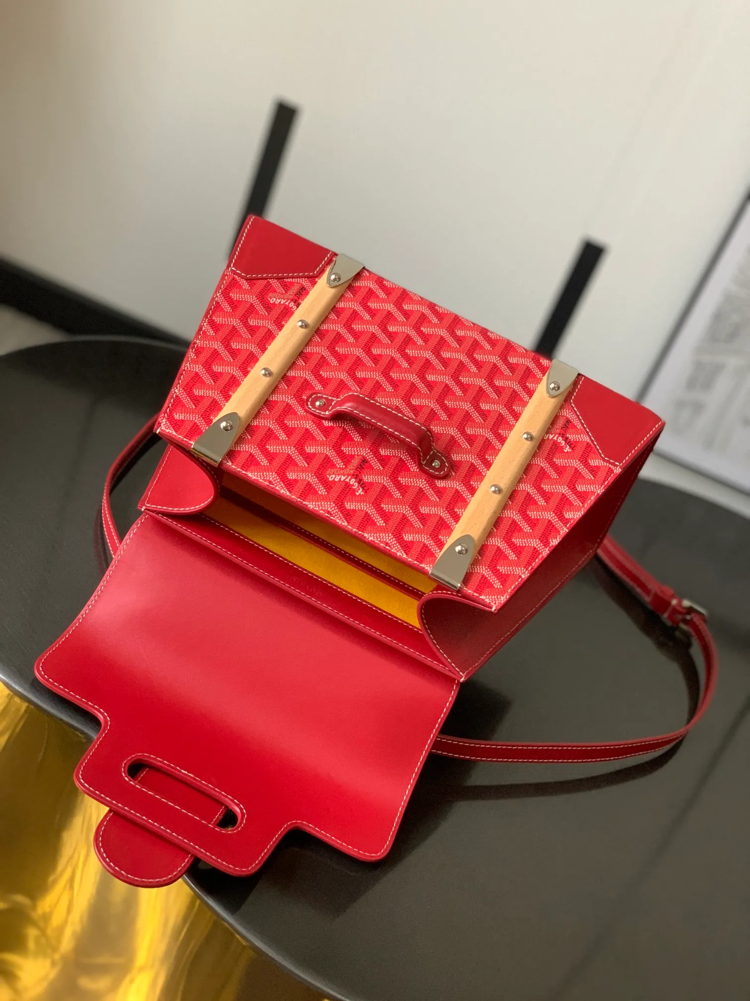 The P1700 original Saïgon bag is one of the signature pieces of the House of Goyard, embodying all the characteristic elements of the brand's boxmaking craftsmanship, such as wood, strips, leather corners and box-making nails. The Saigon Small Bag features a structured design and a removable shoulder strap for a chic and elegant look.  20 cm x 12 cm x 28 cm 🔎LAR 020186-Big Red