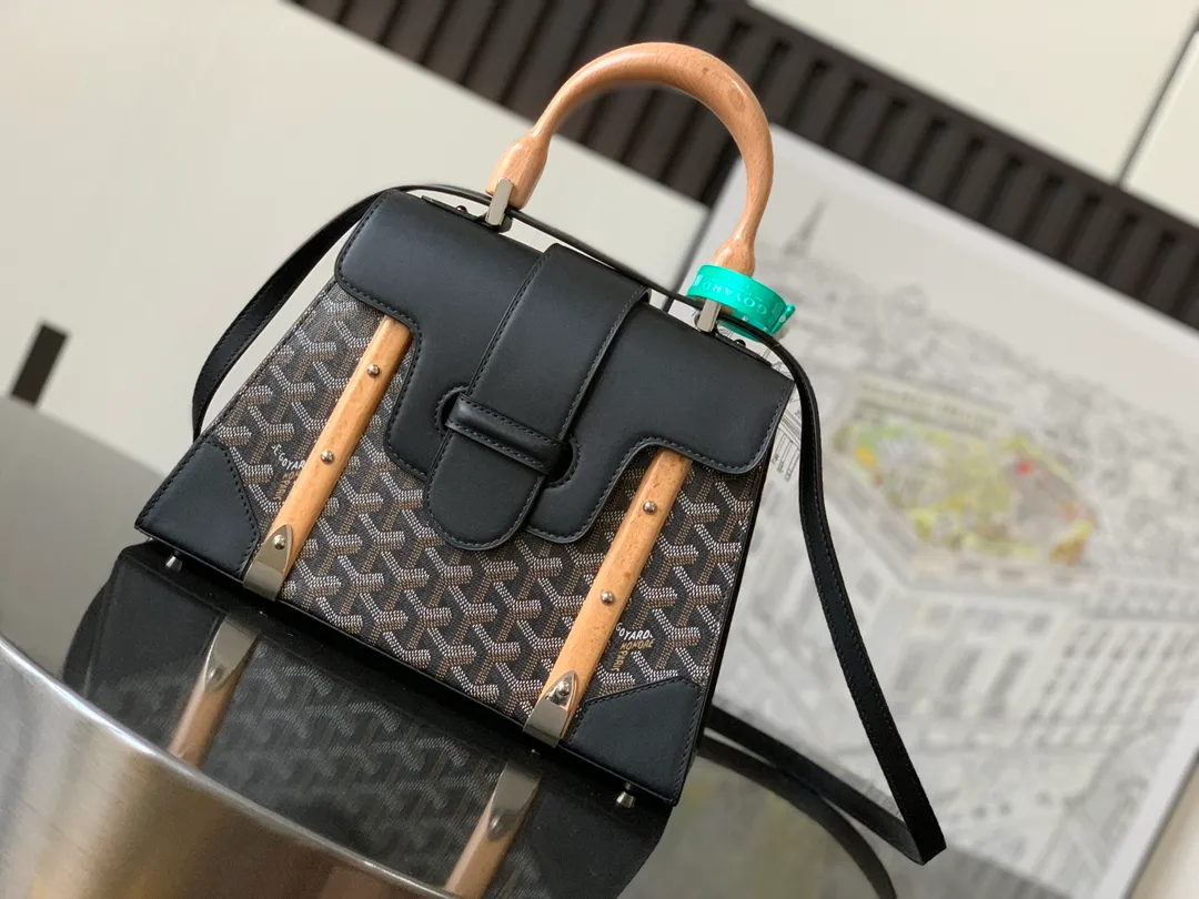 P1700 original. The Saïgon bag is one of the iconic items of the House of Goyard, embodying all the characteristic elements of the brand's box-making craftsmanship, such as wood, strips, leather corners and box-making nails. The Saigon Small Bag features a structured design and a removable shoulder strap for a chic and elegant look.  20 cm x 12 cm x 28 cm 🔎LAR 020186-Black