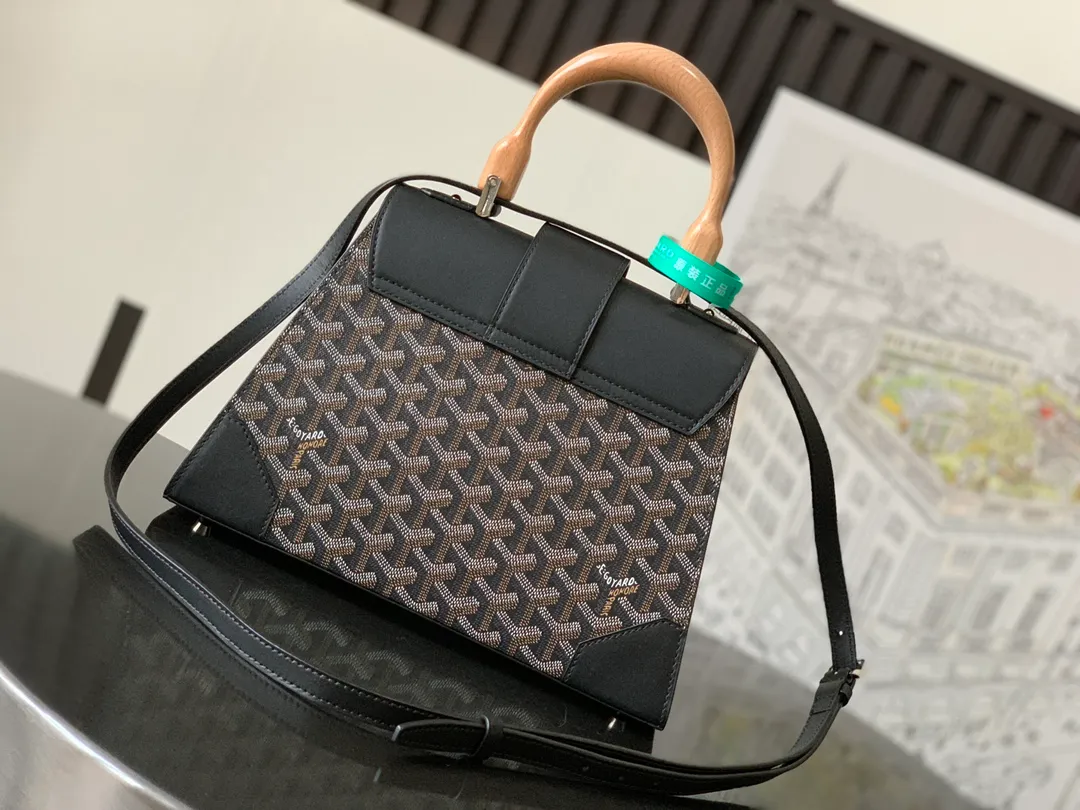 P1700 original. The Saïgon bag is one of the iconic items of the House of Goyard, embodying all the characteristic elements of the brand's box-making craftsmanship, such as wood, strips, leather corners and box-making nails. The Saigon Small Bag features a structured design and a removable shoulder strap for a chic and elegant look.  20 cm x 12 cm x 28 cm 🔎LAR 020186-Black
