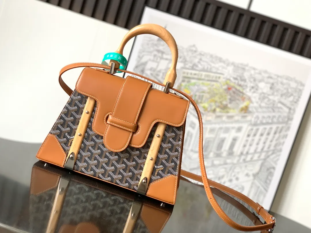 P1700 original Saïgon bag is one of the iconic items of the House of Goyard, embodying all the characteristic elements of the brand's box-making craftsmanship, such as wood, strips, leather corners and box-making nails. The Saigon Small Bag features a structured design and a removable shoulder strap for a chic and elegant look.  20 cm x 12 cm x 28 cm 🔎LAR 020186-Black/Brown