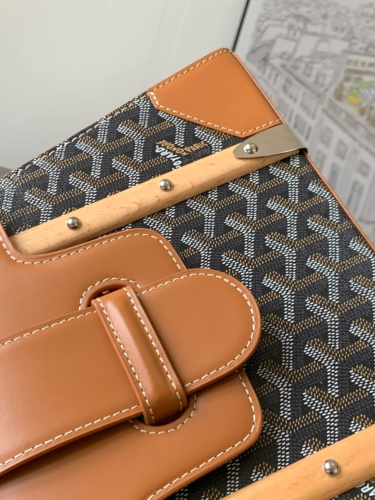 P1700 original Saïgon bag is one of the iconic items of the House of Goyard, embodying all the characteristic elements of the brand's box-making craftsmanship, such as wood, strips, leather corners and box-making nails. The Saigon Small Bag features a structured design and a removable shoulder strap for a chic and elegant look.  20 cm x 12 cm x 28 cm 🔎LAR 020186-Black/Brown