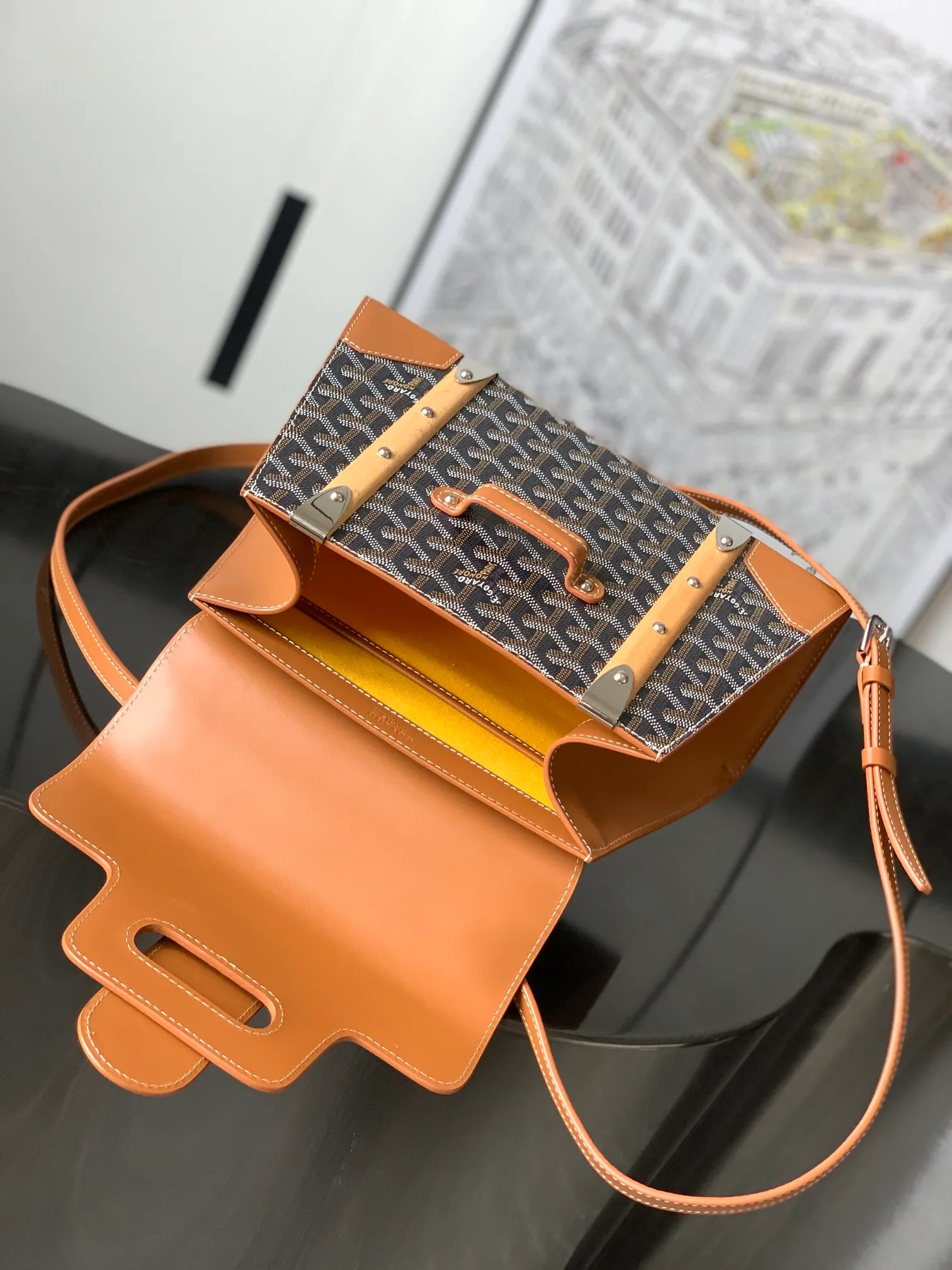 P1700 original Saïgon bag is one of the iconic items of the House of Goyard, embodying all the characteristic elements of the brand's box-making craftsmanship, such as wood, strips, leather corners and box-making nails. The Saigon Small Bag features a structured design and a removable shoulder strap for a chic and elegant look.  20 cm x 12 cm x 28 cm 🔎LAR 020186-Black/Brown