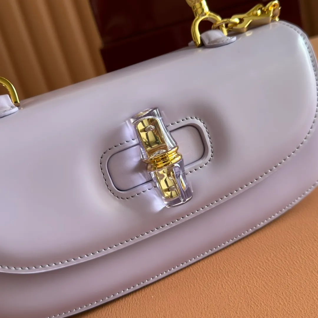 p1680. 💋💋💋 Equipped with full counter packaging [New Product] This small handbag reinterprets the iconic bamboo-shaped accessories with resin and brass details, adding another dazzling masterpiece to the 2025 spring and summer series. The Gucci Bamboo Diva tote adds a pop of color to any look. White glossy buffed leather Resin and brass bamboo hardware Three-level articulated compartments White leather lining Interior: One zippered pocket and a mirror with removable pocket Handle height 10cm Removable and adjustable leather shoulder strap (50cm high); length adjustable between 100cm and 116cm Bamboo lock Model number: 827750 Dimensions: 26.6cm (width) x 13cm (h) x 8 cm (depth) Weight: about 0.9 kg Color: purple full leather/original leather. Made in Italy