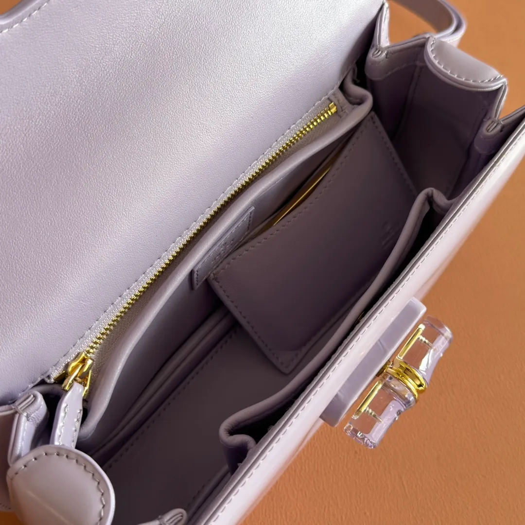 p1680. 💋💋💋 Equipped with full counter packaging [New Product] This small handbag reinterprets the iconic bamboo-shaped accessories with resin and brass details, adding another dazzling masterpiece to the 2025 spring and summer series. The Gucci Bamboo Diva tote adds a pop of color to any look. White glossy buffed leather Resin and brass bamboo hardware Three-level articulated compartments White leather lining Interior: One zippered pocket and a mirror with removable pocket Handle height 10cm Removable and adjustable leather shoulder strap (50cm high); length adjustable between 100cm and 116cm Bamboo lock Model number: 827750 Dimensions: 26.6cm (width) x 13cm (h) x 8 cm (depth) Weight: about 0.9 kg Color: purple full leather/original leather. Made in Italy