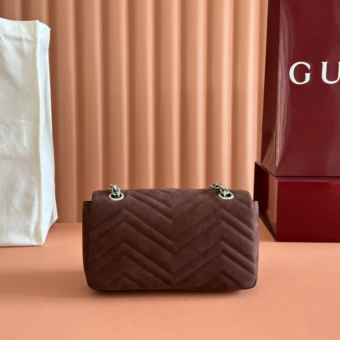 p1260. 💋💋💋【With full set of original counter packaging】The brand's iconic GG Marmont series is ingeniously integrated with double G styling accessories and faceted chain straps to create a soft and fashionable bag. Simple and neat back pockets make medium and large bags more practical. Dark brown quilted V-shaped nubuck Dark brown cowhide leather Silver-toned hardware Beige cotton and linen lining Double G Interior: 1 zippered pocket Exterior: 1 open pocket Sliding chain strap that can be used as a shoulder strap (56cm high) Spring buckle flap Model: 837280 Dimensions: 22cm (W) x 15cm (H) x 6cm (D) Weight: approx. 0.65kg Color: Brown matte. Made in Italy