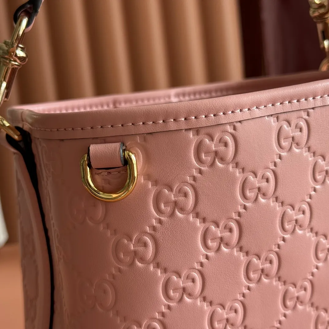 p1140. 💋💋💋 Comes with a full set of original counter packaging [New Product] 2025 Autumn and Winter Series, the GG Emblem series reinterprets the brand's timeless elegance and exquisite craftsmanship. Lined in tonal cotton, this practical bucket bag features an internal compartment. Pink GG embossed leather Light gold tone hardware Light pink cotton lining The bag pictured is sold separately and does not come with the bag charm. Top handle with hook closure (height: 14cm Also equipped with D-ring for attaching removable items Interior: two compartments and one central snap compartment Removable and adjustable leather shoulder strap (height: 52cm - 57.5cm; length: 107cm - 114cm) Magnetic snap closure Model number: 815118. Dimensions: 19cm (W) x 18cm (H) x 11cm (D) Weight: approx. 0.45 kg Color: pink embossed Made in Italy.