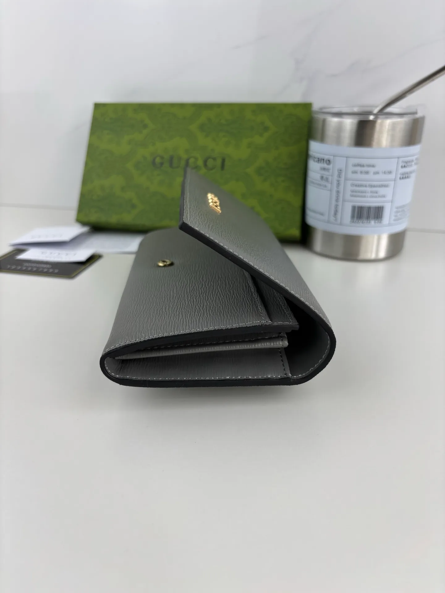 💰170 GUCCl long clip wallet with handwritten Gucci logo. Exploring self-expression with unlimited possibilities has become the spiritual connotation of brand design. Crafted from gray leather, this long clip is embellished with a gold-toned handwritten Gucci logo-shaped hardware, adding a touch of the brand's signature charm to the entire design. Gray leather, gold-tone hardware, taffeta lining, script Gucci logo detail. INTERIOR: Twelve card compartments, two bill compartments, two separate internal compartments and a zipped coin pocket, this classic piece features snap closure Style number: 772638 Dimensions: 19cm x 10cm x 3.5cm Colour: Gray