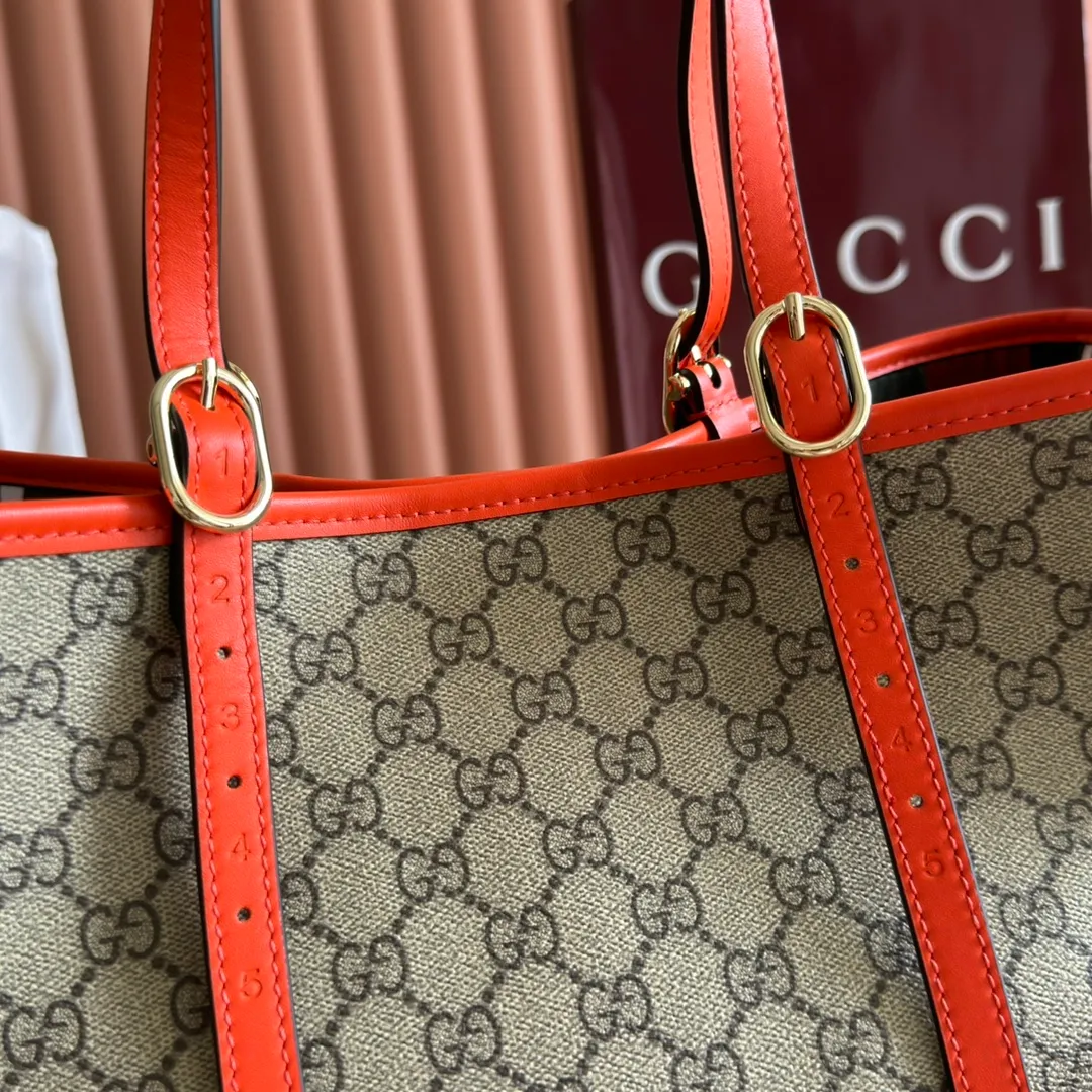 p980. 💋💋💋"With full set of original counter packaging" [New product] GG Emblem series reinterprets the brand's timeless elegance and exquisite craftsmanship. Inspired by the equestrian world, this tote bag features an adjustable top handle with numbered eyelets. New GG monogram coated fabric in beige and dark brown Orange leather trim with contrast stitching Light gold tone hardware Red and green webbing cotton lining The bag pictured is sold separately and does not come with the bag charm. Also features D-ring for hanging removable items Adjustable handle with numbered eyelets (height: 21.5 cm - 31.5 cm) Interior: two compartments and one central zipped compartment Magnetic snap closure Ident.: 815213. Dimensions: 38cm (width) x 25cm (height) x 15cm (depth) Weight: about 0.85kg Color: brown orange PVC/original leather. Made in Italy