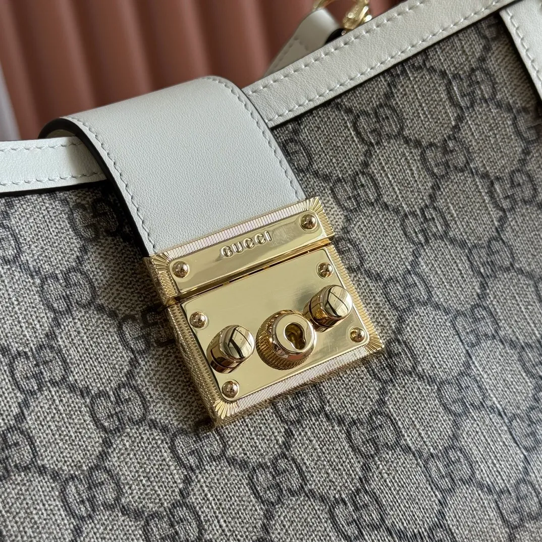 p1100. 💋💋💋Original leather [equipped with full counter packaging] The Padlock series has launched a variety of fashionable bags with various carrying methods, adding color to the 2025 early autumn series. This tote is lined with webbing, reminiscent of the brand's signature pattern. Off-white and dark brown GG monogram coated fabric Off-white leather trim Light gold tone hardware Red and green webbing cotton lining Interior: One zippered pocket Carry handle (10 cm height) Removable and adjustable leather shoulder strap (height: 114 cm - 124 cm; length: 55 cm - 60 cm) Padlock closure with leather keychain Ident.: 838992. Dimensions: 25.5cm (width) x 17.5cm (height) x 10cm (depth) Weight: approx. 0.6kg Color: brown white pvc. Made in Italy