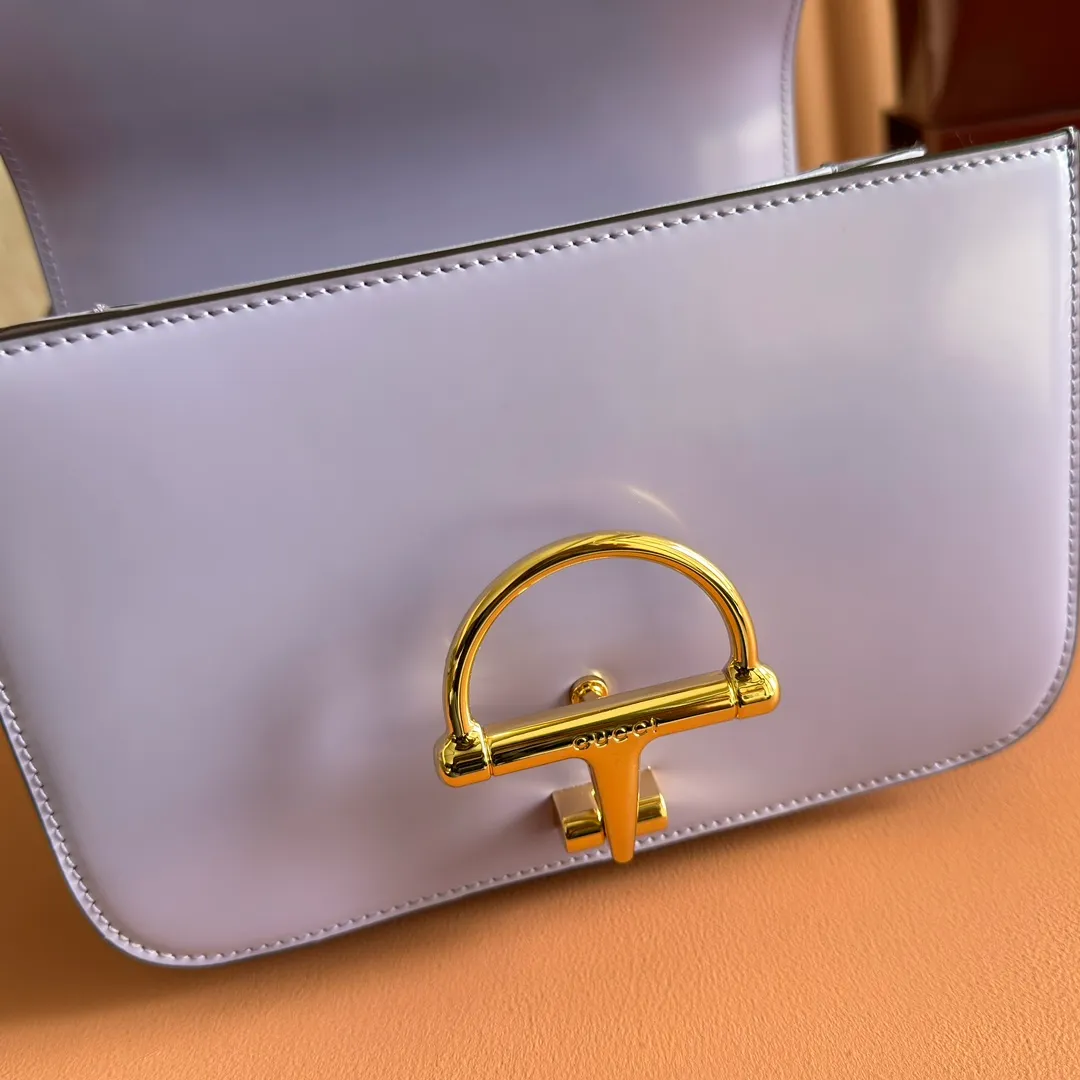 p1640. 💋💋💋【With full set of original counter packaging】2025 autumn and winter series, the Gucci Siena series small shoulder bag continues the evolution of the iconic element of Gucci's classic horsebit. Crafted from fine glossy leather, this shoulder bag has a structured shape and a half-horsebit buckle design from the 1970s. Finished with gold-tone hardware, the interior is lined with three levels of gusseting and a zipped pocket. Black fine glossy leather Gold-tone hardware Black leather lining Interior: 3-level fastening and 1 zipped pocket Shoulder straps: Height: 23cm – 25cm; Length: 127cm Half-horsebit snap fastener Ident: 846705. Dimensions: 22.5cm (width) x 14cm (height) x 8cm (depth) Weight: approx. 0.7kg Color: Purple full leather. Made in Italy
