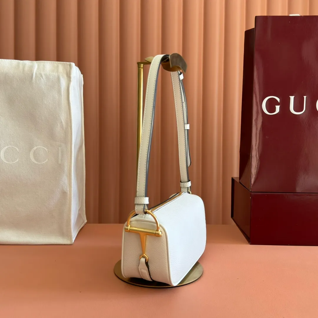 p1060💋💋💋【With full set of original counter packaging】The brand interprets iconic elements from a contemporary perspective and re-presents the Gucci half-horse bit design. It uses soft cow leather that fits the body shape to inject new style into classic accessories. This mini bag is crafted from soft grained leather and features a half horsebit detail on the side. Green grained soft leather. Light gold tone hardware. Tonal cotton and linen blend lining. Half horsebit buckle. Calf leather shoulder strap (23cm high). Zip closure. Ident.: 860784. Dimensions: 19cm (width) x 19.5cm (height) x 9cm (depth) Weight: approx. 272g Color: white/full leather.