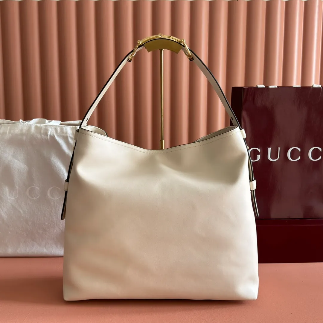p1760💋💋💋【With full set of original counter gift bag packaging】2025 autumn and winter series, Gucci Beatrix series handbags are crafted from black cow leather material and equipped with iconic horsebit detail shoulder straps, adding brand connotation to the casual silhouette. Gold-toned accessories add a refined touch, and a zippered pocket inside keeps daily essentials secure. Combining elegant design with practical performance, it easily accommodates daily essentials. Black soft glossy calf leather Gold-tone hardware Black cotton and linen blend lining Horsebit detail on shoulder strap Interior: Zip pocket Adjustable shoulder strap Height: 26cm - 33cm; Length: 94cm Ident: 850546. Dimensions: 40cm (width) x 36cm (height) x 12cm (depth) Weight: approx. 1kg Color: White full leather. Made in Italy