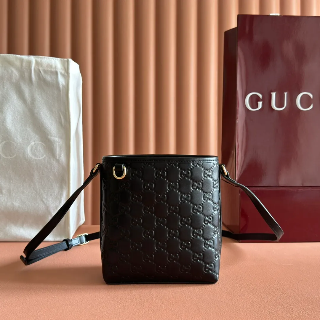p960. 💋💋💋"With full set of original counter packaging" [New product] 2025 autumn and winter series, this mini bucket bag reinterprets brand elements with practical design, adding a masterpiece to the new GG Emblem series. This mini bucket bag has a simple and compact silhouette with exquisite details. It is designed with a long shoulder strap and is comfortable to carry, making it a versatile item suitable for day and night occasions. Black GG printed embossed leather Gold tone hardware Black cotton and linen lining The bag pictured is sold separately and does not come with the bag charm. Adjustable leather shoulder strap Height: 52-58 cm Model: 847090. Dimensions: 15 (18) cm (width) x 18 cm (height) x 8 cm (depth) Weight: approx. 0.211 kg Color: Black embossed. Made in Italy