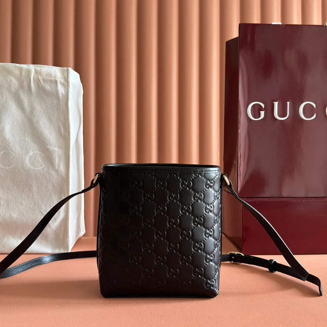 p960. 💋💋💋"With full set of original counter packaging" [New product] 2025 autumn and winter series, this mini bucket bag reinterprets brand elements with practical design, adding a masterpiece to the new GG Emblem series. This mini bucket bag has a simple and compact silhouette with exquisite details. It is designed with a long shoulder strap and is comfortable to carry, making it a versatile item suitable for day and night occasions. Black GG printed embossed leather Gold tone hardware Black cotton and linen lining The bag pictured is sold separately and does not come with the bag charm. Adjustable leather shoulder strap Height: 52-58 cm Model: 847090. Dimensions: 15 (18) cm (width) x 18 cm (height) x 8 cm (depth) Weight: approx. 0.211 kg Color: Black embossed. Made in Italy
