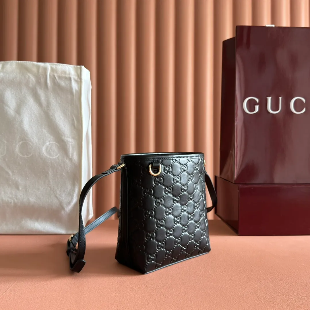 p960. 💋💋💋"With full set of original counter packaging" [New product] 2025 autumn and winter series, this mini bucket bag reinterprets brand elements with practical design, adding a masterpiece to the new GG Emblem series. This mini bucket bag has a simple and compact silhouette with exquisite details. It is designed with a long shoulder strap and is comfortable to carry, making it a versatile item suitable for day and night occasions. Black GG printed embossed leather Gold tone hardware Black cotton and linen lining The bag pictured is sold separately and does not come with the bag charm. Adjustable leather shoulder strap Height: 52-58 cm Model: 847090. Dimensions: 15 (18) cm (width) x 18 cm (height) x 8 cm (depth) Weight: approx. 0.211 kg Color: Black embossed. Made in Italy