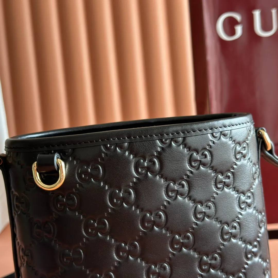 p960. 💋💋💋"With full set of original counter packaging" [New product] 2025 autumn and winter series, this mini bucket bag reinterprets brand elements with practical design, adding a masterpiece to the new GG Emblem series. This mini bucket bag has a simple and compact silhouette with exquisite details. It is designed with a long shoulder strap and is comfortable to carry, making it a versatile item suitable for day and night occasions. Black GG printed embossed leather Gold tone hardware Black cotton and linen lining The bag pictured is sold separately and does not come with the bag charm. Adjustable leather shoulder strap Height: 52-58 cm Model: 847090. Dimensions: 15 (18) cm (width) x 18 cm (height) x 8 cm (depth) Weight: approx. 0.211 kg Color: Black embossed. Made in Italy