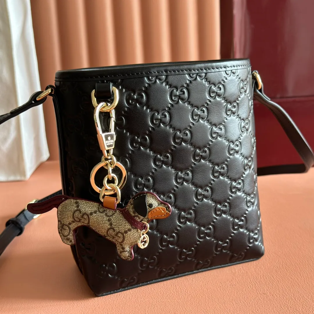 p960. 💋💋💋"With full set of original counter packaging" [New product] 2025 autumn and winter series, this mini bucket bag reinterprets brand elements with practical design, adding a masterpiece to the new GG Emblem series. This mini bucket bag has a simple and compact silhouette with exquisite details. It is designed with a long shoulder strap and is comfortable to carry, making it a versatile item suitable for day and night occasions. Black GG printed embossed leather Gold tone hardware Black cotton and linen lining The bag pictured is sold separately and does not come with the bag charm. Adjustable leather shoulder strap Height: 52-58 cm Model: 847090. Dimensions: 15 (18) cm (width) x 18 cm (height) x 8 cm (depth) Weight: approx. 0.211 kg Color: Black embossed. Made in Italy