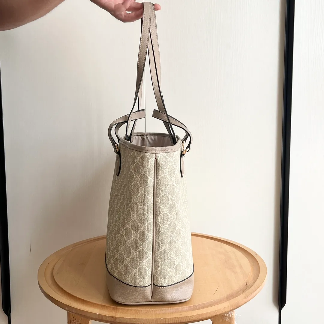 Actual shot #💰300 Model: 739730 Size: 38.5x28.5x15cm The GG Ophidia series is still one of Gucci’s iconic handbags. The brand launches new styles every season, creating versatile accessories that suit every look. Two handles give this tote a multi-functional character, allowing it to be worn as a shoulder bag or as a handbag. As a classic design element, the Double G has been deeply embedded in the brand's design. On this handbag, it is presented in a dazzling manner, contrasting with the GG Supreme canvas and brown leather piping.