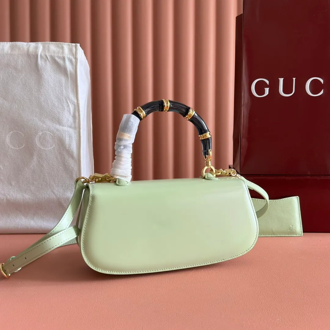 p1680. 💋💋💋 Equipped with full counter packaging [New Product] This small handbag reinterprets the iconic bamboo-shaped accessories with resin and brass details, adding another dazzling masterpiece to the 2025 spring and summer series. The Gucci Bamboo Diva tote adds a pop of color to any look. White glossy buffed leather Resin and brass bamboo hardware Three-level articulated compartments White leather lining Interior: One zippered pocket and a mirror with removable pocket Handle height 10cm Removable and adjustable leather shoulder strap (50cm high); length adjustable between 100cm and 116cm Bamboo lock Model number: 827750 Dimensions: 26.6cm (width) x 13cm (h) x 8 cm (depth) Weight: about 0.9 kg Color: green full leather/original leather. Made in Italy