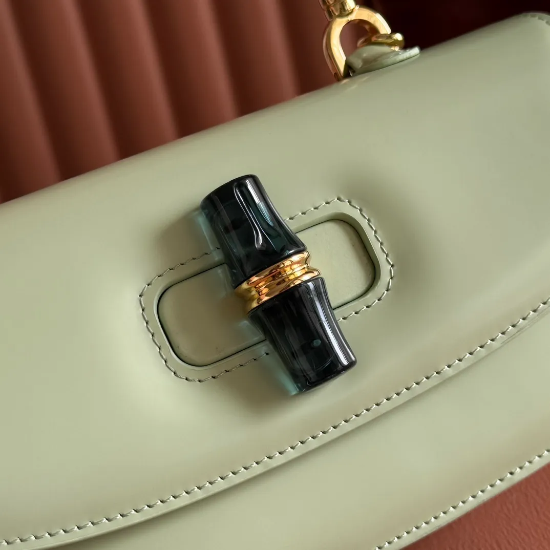 p1680. 💋💋💋 Equipped with full counter packaging [New Product] This small handbag reinterprets the iconic bamboo-shaped accessories with resin and brass details, adding another dazzling masterpiece to the 2025 spring and summer series. The Gucci Bamboo Diva tote adds a pop of color to any look. White glossy buffed leather Resin and brass bamboo hardware Three-level articulated compartments White leather lining Interior: One zippered pocket and a mirror with removable pocket Handle height 10cm Removable and adjustable leather shoulder strap (50cm high); length adjustable between 100cm and 116cm Bamboo lock Model number: 827750 Dimensions: 26.6cm (width) x 13cm (h) x 8 cm (depth) Weight: about 0.9 kg Color: green full leather/original leather. Made in Italy
