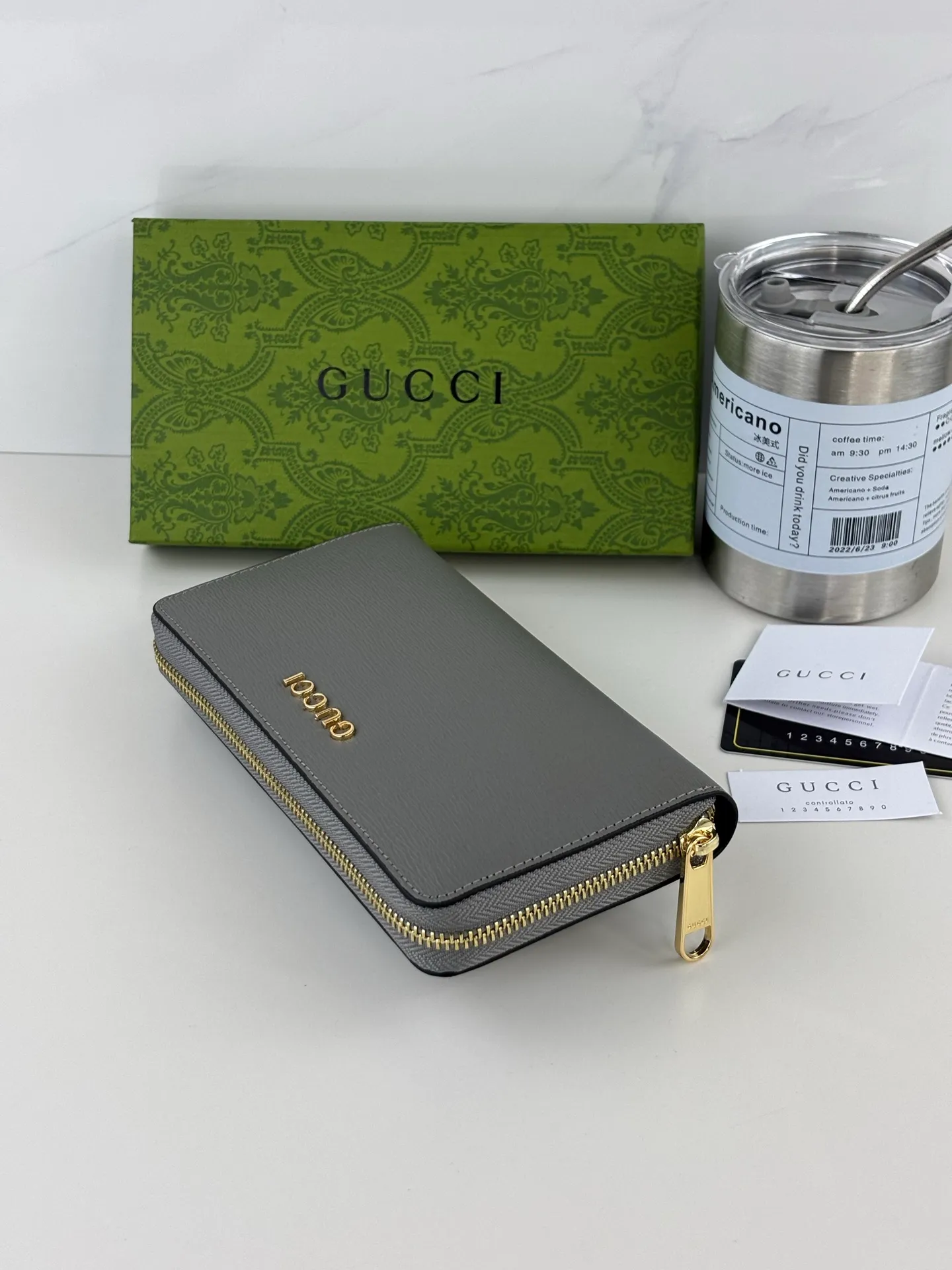 💰170 GUCCl Long zipper wallet with handwritten Gucci logo. Exploring self-expression with unlimited possibilities has become the spiritual connotation of brand design. Crafted from gray leather, this long clip is embellished with a gold-toned handwritten Gucci logo-shaped hardware, adding a touch of the brand's signature charm to the entire design. Gray leather, gold-tone hardware, taffeta lining, scripted Gucci logo detail. Interior: Six card compartments, two bill compartments, two separate internal compartments and a zippered coin pocket, this classic piece features a zipper closure Style number: 772642 Dimensions: 19cm x 10cm x 3.5cm Colour: Gray