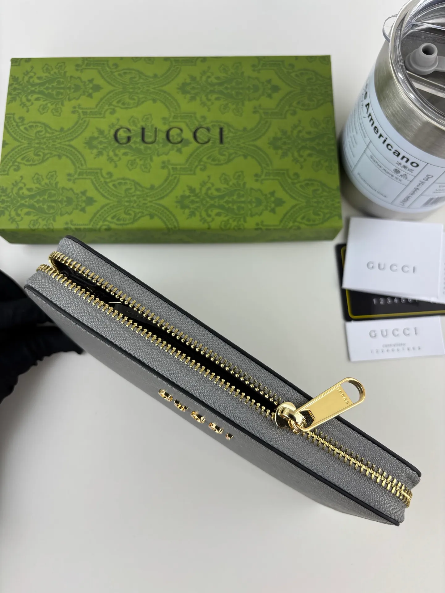 💰170 GUCCl Long zipper wallet with handwritten Gucci logo. Exploring self-expression with unlimited possibilities has become the spiritual connotation of brand design. Crafted from gray leather, this long clip is embellished with a gold-toned handwritten Gucci logo-shaped hardware, adding a touch of the brand's signature charm to the entire design. Gray leather, gold-tone hardware, taffeta lining, scripted Gucci logo detail. Interior: Six card compartments, two bill compartments, two separate internal compartments and a zippered coin pocket, this classic piece features a zipper closure Style number: 772642 Dimensions: 19cm x 10cm x 3.5cm Colour: Gray