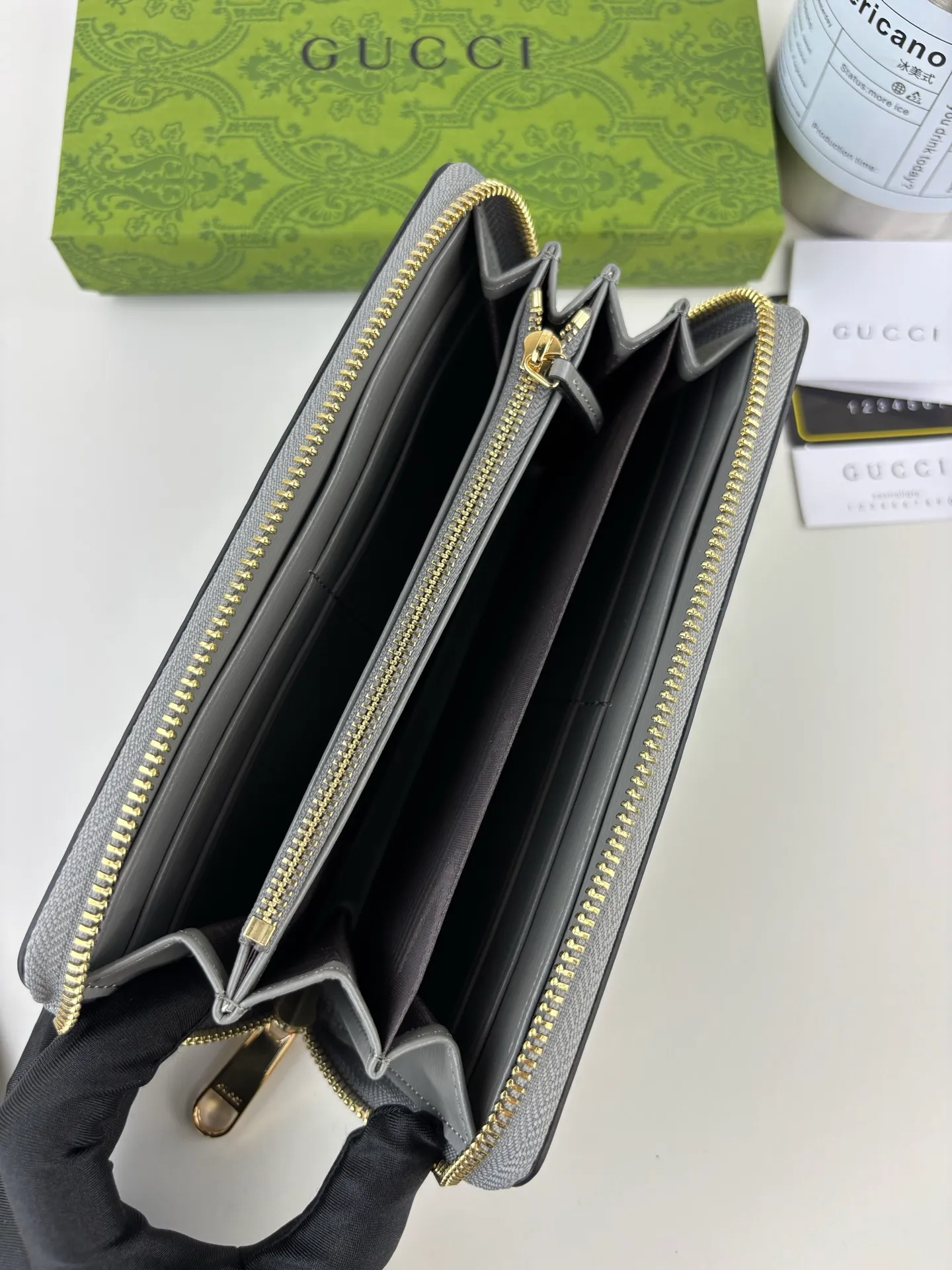 💰170 GUCCl Long zipper wallet with handwritten Gucci logo. Exploring self-expression with unlimited possibilities has become the spiritual connotation of brand design. Crafted from gray leather, this long clip is embellished with a gold-toned handwritten Gucci logo-shaped hardware, adding a touch of the brand's signature charm to the entire design. Gray leather, gold-tone hardware, taffeta lining, scripted Gucci logo detail. Interior: Six card compartments, two bill compartments, two separate internal compartments and a zippered coin pocket, this classic piece features a zipper closure Style number: 772642 Dimensions: 19cm x 10cm x 3.5cm Colour: Gray
