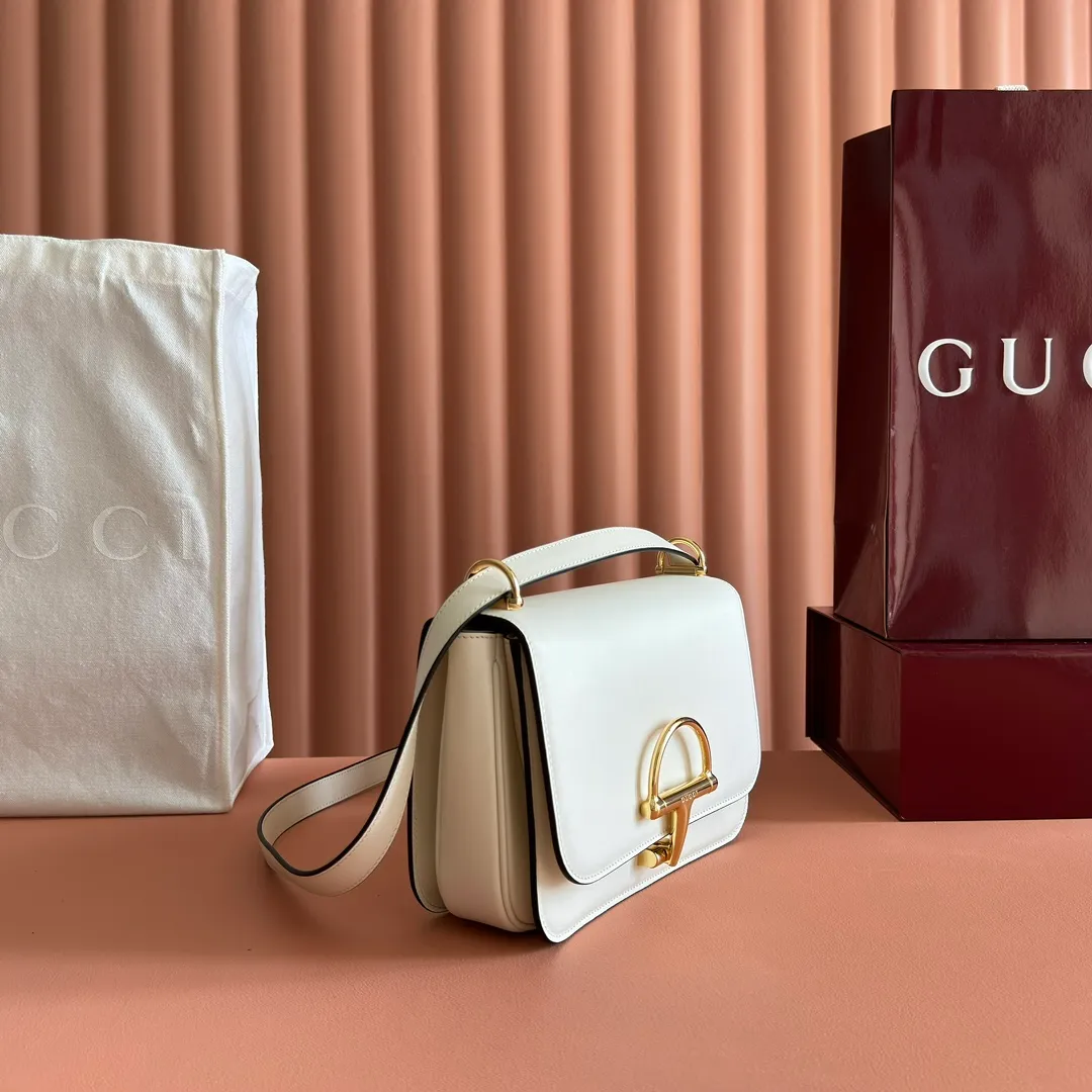 p1640. 💋💋💋【With full set of original counter packaging】2025 autumn and winter series, the Gucci Siena series small shoulder bag continues the evolution of the iconic element of Gucci's classic horsebit. Crafted from fine glossy leather, this shoulder bag has a structured shape and a half-horsebit buckle design from the 1970s. Finished with gold-tone hardware, the interior is lined with three levels of gusseting and a zipped pocket. Black fine glossy leather Gold-tone hardware Black leather lining Interior: 3-level fastening and 1 zipped pocket Shoulder straps: Height: 23cm – 25cm; Length: 127cm Half-horsebit snap fastener Ident: 846705. Dimensions: 22.5cm (width) x 14cm (height) x 8cm (depth) Weight: approx. 0.7kg Color: White full leather. Made in Italy
