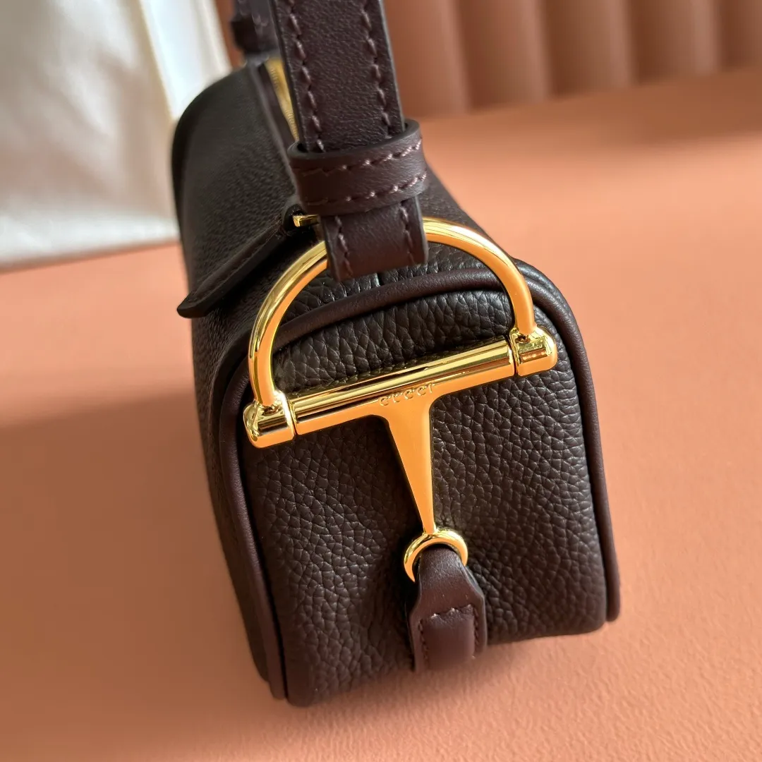 p1060💋💋💋【With full set of original counter packaging】The brand interprets iconic elements from a contemporary perspective and re-presents the Gucci half-horse bit design. It uses soft cow leather that fits the body shape to inject new style into classic accessories. This mini bag is crafted from soft grained leather and features a half horsebit detail on the side. Green grained soft leather. Light gold tone hardware. Tonal cotton and linen blend lining. Half horsebit buckle. Calf leather shoulder strap (23cm high). Zip closure. Ident.: 860784. Dimensions: 19cm (width) x 19.5cm (height) x 9cm (depth) Weight: approximately 272g Color: brown/full leather.