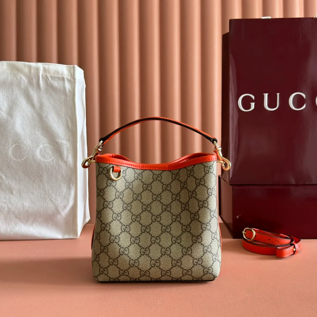 p920. 💋💋💋"With full set of original counter packaging" [New product] GG Emblem series reinterprets the brand's timeless elegance and exquisite craftsmanship. This bucket bag is lined in webbed cotton and features an internal compartment for added functionality. New GG monogram coated fabric in beige and dark brown Orange leather piping Light gold tone hardware Red and green web cotton lining The bag pictured is sold separately and does not come with the bag charm. Top handle with hook closure (height: 14 cm) Additional D-ring for attaching removable items Interior: two compartments and a central snap-stud compartment Removable and adjustable leather shoulder strap (height: 52 cm - 57.5 cm; length: 107 cm - 114 cm) Magnetic snap closure Ident.: 815118. Dimensions: 19 cm (width) x 18 cm (height) x 11 cm (depth) Weight: about 0.45 kg Color: brown orange pvc/original leather. Made in Italy
