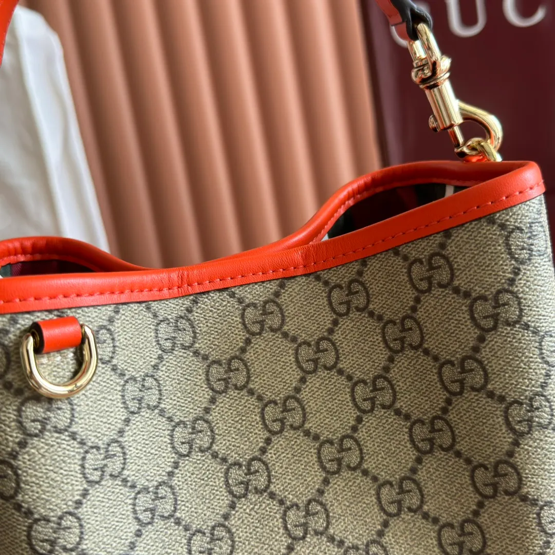 p920. 💋💋💋"With full set of original counter packaging" [New product] GG Emblem series reinterprets the brand's timeless elegance and exquisite craftsmanship. This bucket bag is lined in webbed cotton and features an internal compartment for added functionality. New GG monogram coated fabric in beige and dark brown Orange leather piping Light gold tone hardware Red and green web cotton lining The bag pictured is sold separately and does not come with the bag charm. Top handle with hook closure (height: 14 cm) Additional D-ring for attaching removable items Interior: two compartments and a central snap-stud compartment Removable and adjustable leather shoulder strap (height: 52 cm - 57.5 cm; length: 107 cm - 114 cm) Magnetic snap closure Ident.: 815118. Dimensions: 19 cm (width) x 18 cm (height) x 11 cm (depth) Weight: about 0.45 kg Color: brown orange pvc/original leather. Made in Italy