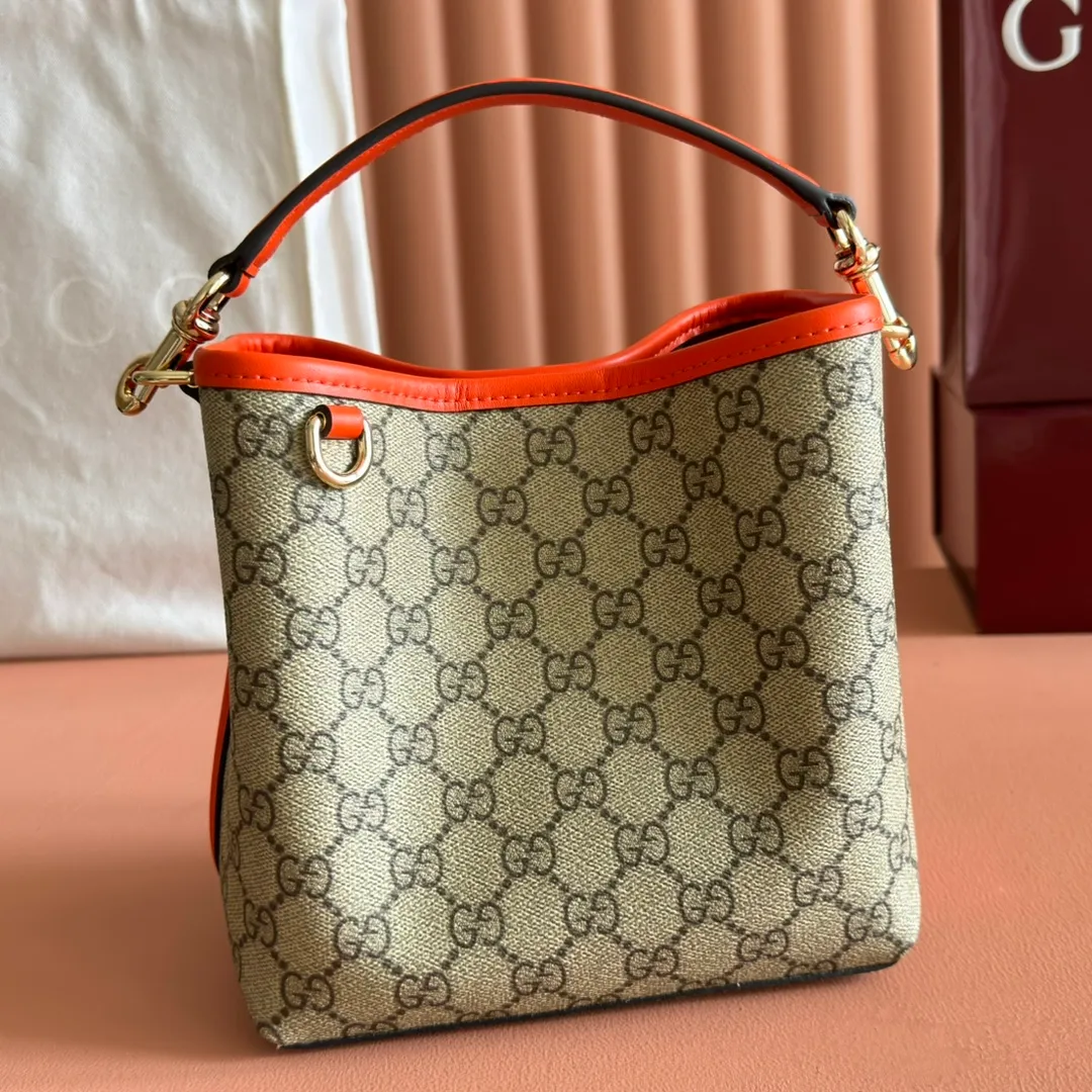 p920. 💋💋💋"With full set of original counter packaging" [New product] GG Emblem series reinterprets the brand's timeless elegance and exquisite craftsmanship. This bucket bag is lined in webbed cotton and features an internal compartment for added functionality. New GG monogram coated fabric in beige and dark brown Orange leather piping Light gold tone hardware Red and green web cotton lining The bag pictured is sold separately and does not come with the bag charm. Top handle with hook closure (height: 14 cm) Additional D-ring for attaching removable items Interior: two compartments and a central snap-stud compartment Removable and adjustable leather shoulder strap (height: 52 cm - 57.5 cm; length: 107 cm - 114 cm) Magnetic snap closure Ident.: 815118. Dimensions: 19 cm (width) x 18 cm (height) x 11 cm (depth) Weight: about 0.45 kg Color: brown orange pvc/original leather. Made in Italy