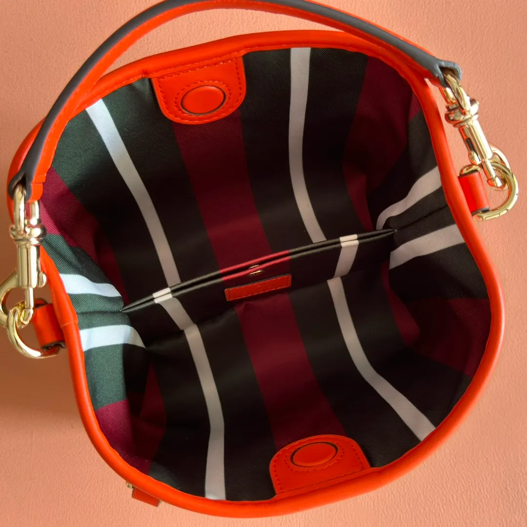 p920. 💋💋💋"With full set of original counter packaging" [New product] GG Emblem series reinterprets the brand's timeless elegance and exquisite craftsmanship. This bucket bag is lined in webbed cotton and features an internal compartment for added functionality. New GG monogram coated fabric in beige and dark brown Orange leather piping Light gold tone hardware Red and green web cotton lining The bag pictured is sold separately and does not come with the bag charm. Top handle with hook closure (height: 14 cm) Additional D-ring for attaching removable items Interior: two compartments and a central snap-stud compartment Removable and adjustable leather shoulder strap (height: 52 cm - 57.5 cm; length: 107 cm - 114 cm) Magnetic snap closure Ident.: 815118. Dimensions: 19 cm (width) x 18 cm (height) x 11 cm (depth) Weight: about 0.45 kg Color: brown orange pvc/original leather. Made in Italy