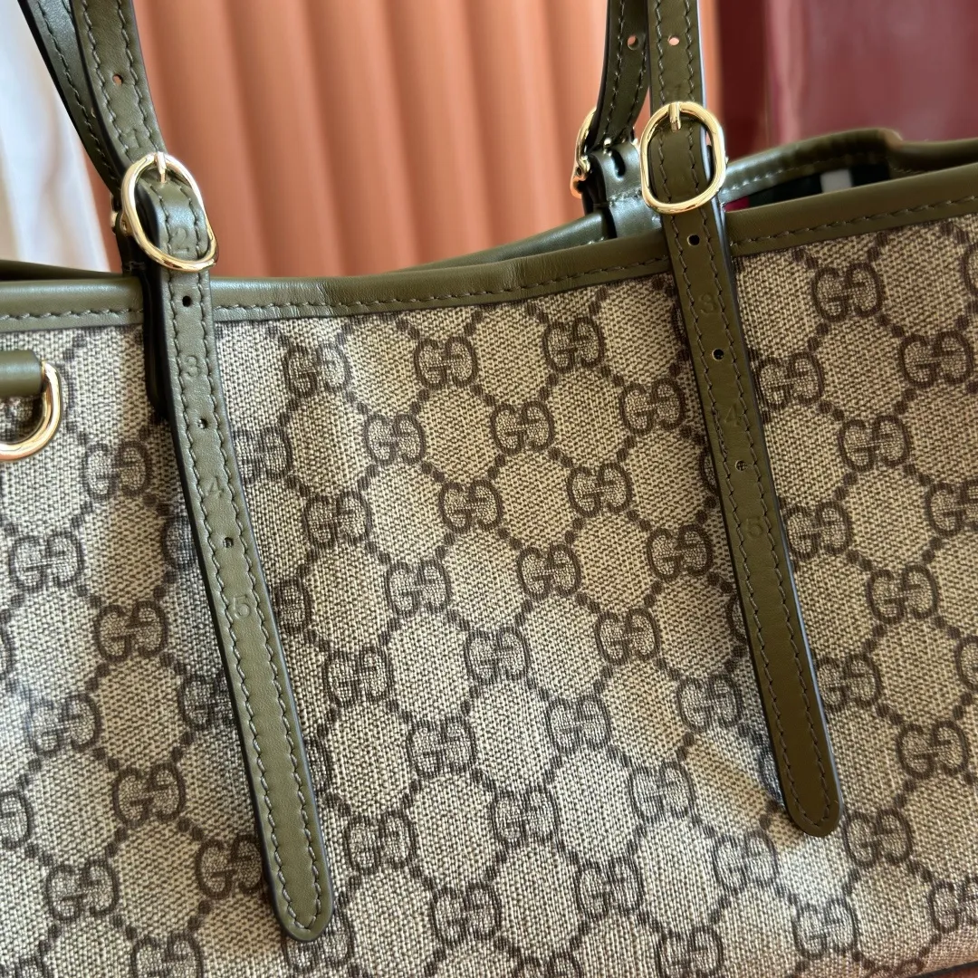 p960. 💋💋💋Original leather configuration with full counter packaging [New product] GG Emblem series reinterprets the brand's timeless elegance and exquisite craftsmanship. Crafted in light pink, this small tote bag features adjustable handles with eyelets for an elegant look inspired by the equestrian world. Black GG Monogram coated fabric Black leather trim Light gold tone hardware Webbing cotton lining Additional D-ring for hanging removable items Adjustable handle with numbered eyelets; Height 18cm - 28cm Interior: 2 compartments and 1 central zippered compartment Adjustable leather shoulder strap (H 51.5cm - 57cm); length adjustable between 104cm and 114cm Magnetic snap closure Model: 815214. Dimensions: 30cm (width) x 18cm (height) x 11cm (depth) Weight: about 0.8kg Color: green/original leather. Made in Italy