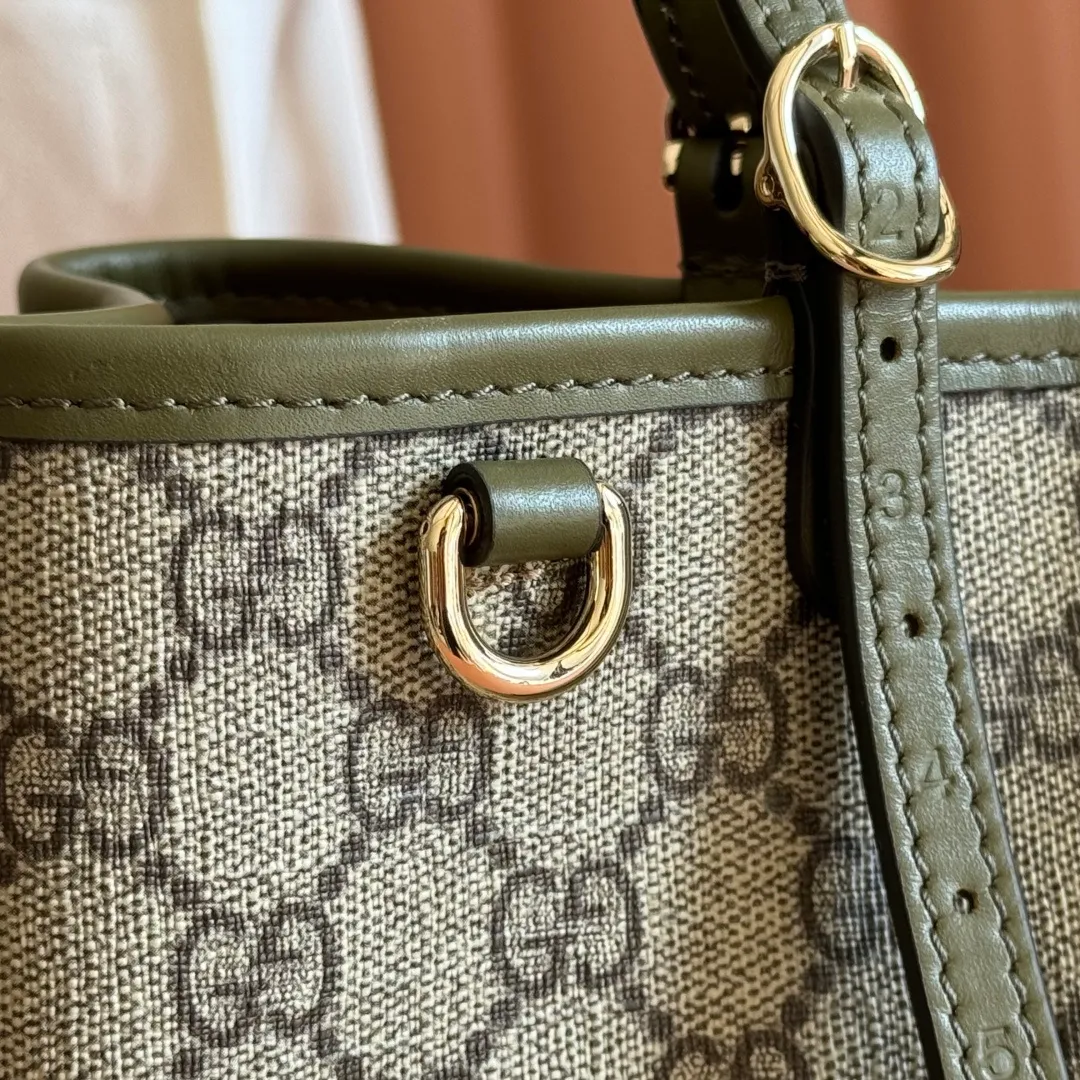 p960. 💋💋💋Original leather configuration with full counter packaging [New product] GG Emblem series reinterprets the brand's timeless elegance and exquisite craftsmanship. Crafted in light pink, this small tote bag features adjustable handles with eyelets for an elegant look inspired by the equestrian world. Black GG Monogram coated fabric Black leather trim Light gold tone hardware Webbing cotton lining Additional D-ring for hanging removable items Adjustable handle with numbered eyelets; Height 18cm - 28cm Interior: 2 compartments and 1 central zippered compartment Adjustable leather shoulder strap (H 51.5cm - 57cm); length adjustable between 104cm and 114cm Magnetic snap closure Model: 815214. Dimensions: 30cm (width) x 18cm (height) x 11cm (depth) Weight: about 0.8kg Color: green/original leather. Made in Italy