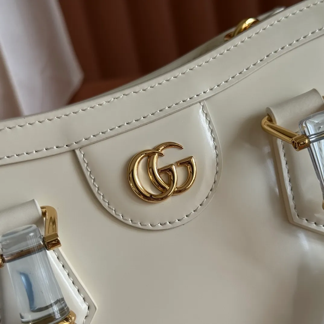 p1560. 💋💋💋【With full set of original counter packaging】【New Product】In the 2025 spring and summer series, the Gucci Diana series reinterprets classic bamboo accessories with resin and brass details. There are many ways to carry it, it can be carried cross-body or on the shoulder. Light purple glossy polished sheepskin Gold-tone hardware Bamboo shaped resin and brass handles Light purple sheepskin lining Double G Interior: One open pocket 8 cm high Removable and adjustable sheepskin shoulder strap (48 to 55 cm high); length adjustable from 93 to 109 cm Ident.: 832936. Dimensions: 20cm (width) x 16cm (height) x 10cm (depth) Weight: approx. 0.95kg Color: White full leather. Made in Italy