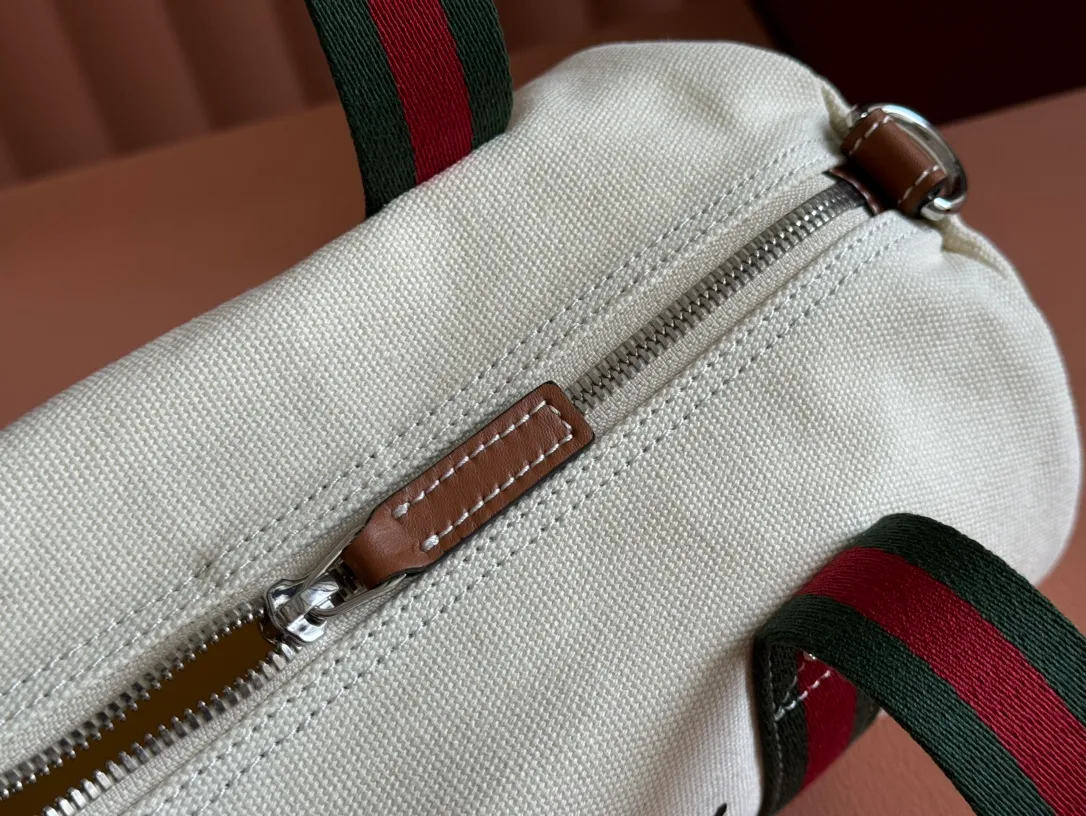 p960. 💋💋💋"With full set of original counter packaging"💕[New Product] With the theme of freedom, vitality and community, the 2025 spring and summer series newly presents a variety of travel items and men's bags, adding more fun to travel and exploration. This canvas travel bag features embellished stitching at the top, blue leather piping and a 'Gucci Made in Italy' badge printed on the front. Dark blue canvas Dark blue leather trimming "Gucci Made in Italy" and badge print Red and green webbing Top stitching detail Interior: 1 side handle Handle height: 12.5cm Adjustable webbing and canvas shoulder strap (55cm height); length adjustable from 77cm to 136cm Zip closure Ident.: 816865. Dimensions: 30cm (W) x 16cm (H) x 15cm (D) Weight: Approx. 0.54kg Color: White canvas. Made in Italy
