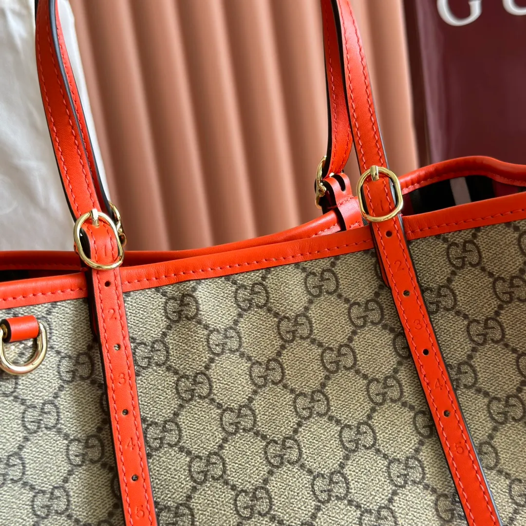 p960. 💋💋💋"With full set of original counter packaging" [New product] GG Emblem series reinterprets the brand's timeless elegance and exquisite craftsmanship. Inspired by the equestrian world, this tote bag features an adjustable top handle with numbered eyelets. Beige and dark brown GG monogram coated fabric Orange leather trim with contrasting stitching Light gold tone hardware Red and green webbing cotton lining The bag pictured is sold separately and does not come with the bag charm. Also features D-ring for attaching removable items Adjustable handle with numbered eyelets (height: 18cm - 28cm) Interior: two compartments and a central zippered compartment Adjustable leather shoulder strap (height: 51.5cm - 57cm; length: 104cm - 114cm) Magnetic snap closure Ident No.: 815214. Dimensions: 30cm (width) x 18cm (height) x 11cm (depth) Weight: approx. 0.8kg Color: Brown Orange/PVC. Made in Italy