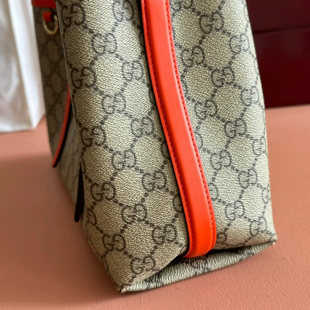 p960. 💋💋💋"With full set of original counter packaging" [New product] GG Emblem series reinterprets the brand's timeless elegance and exquisite craftsmanship. Inspired by the equestrian world, this tote bag features an adjustable top handle with numbered eyelets. Beige and dark brown GG monogram coated fabric Orange leather trim with contrasting stitching Light gold tone hardware Red and green webbing cotton lining The bag pictured is sold separately and does not come with the bag charm. Also features D-ring for attaching removable items Adjustable handle with numbered eyelets (height: 18cm - 28cm) Interior: two compartments and a central zippered compartment Adjustable leather shoulder strap (height: 51.5cm - 57cm; length: 104cm - 114cm) Magnetic snap closure Ident No.: 815214. Dimensions: 30cm (width) x 18cm (height) x 11cm (depth) Weight: approx. 0.8kg Color: Brown Orange/PVC. Made in Italy