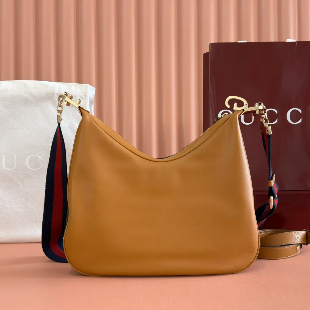 p1660. 📣📣📣【Original leather accessories🌈(equipped with full counter packaging)🔥🔥702823Gucci The Attache large shoulder bag "Gucci March of Love" is a new interpretation of the brand's archive elements, paying tribute to the enduring charm of Hollywood. This accessory features a recognizable crescent shape, and the G hook buckle adds a unique design aesthetic. The classic accessories are combined with soft materials to express retro charm. This large shoulder bag is made of beige and blue GG Supreme canvas, decorated with red and blue webbing. Hide details Beige and blue GG Supreme canvas with red and blue webbing. Gold-tone hardware Cotton and linen lining Additional leather shoulder strap Interior: 1 zipped pocket Removable webbing shoulder strap (50cm high) G-hook fastening with zip 35cm (W) x 32cm (H) x 6cm (D) Made in Italy