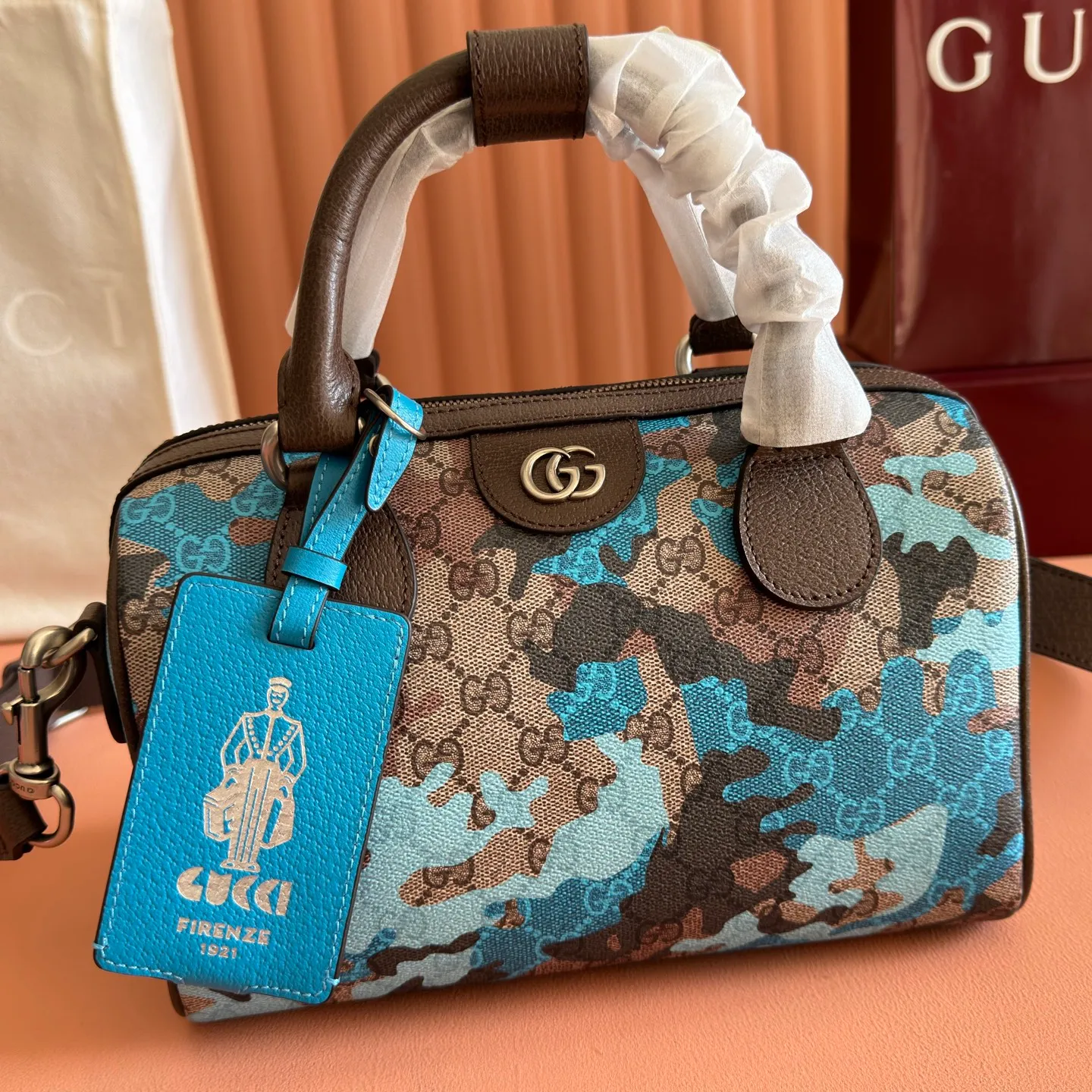 p1240💋💋💋【Original configuration counter complete package】Vivid camouflage combined with unique color matching, a new interpretation of the classic GG pattern. This travel bag is crafted from coated fabric with a marbled GG monogram pattern and features a matching ID plaque. Coated fabric with pink and red camouflage marbled GG monogram Brown, pink and red leather trim Palladium-toned hardware Unique cotton and linen lining Double G Interior: 1 zip pocket External: 1 removable bellman ID tag Handle height: 11 cm Removable and adjustable leather shoulder strap (height: 110 cm - 128 cm) Zip closure Ident No.: 854860. Dimensions: 25cm (width) x 16cm (height) x 14cm (depth) Weight: approx. 856g Color: camouflage blue/PVC.