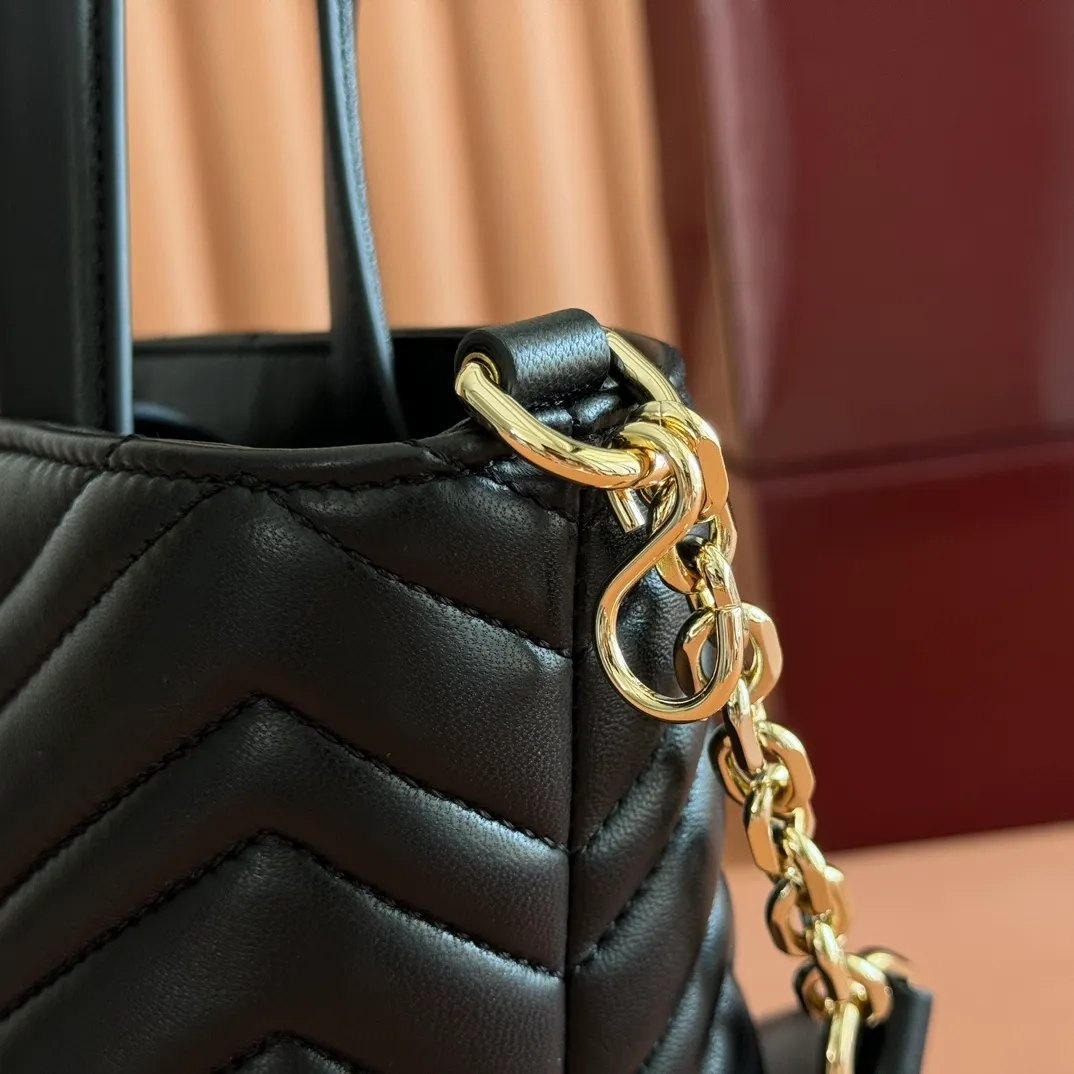 p1280. 💋💋💋 Comes with a complete set of original counter packaging [New product] This tote bag injects novel charm into the GG Marmont series with a new silhouette in the 2025 autumn and winter series. It can transform from a structural tote bag to a soft-lined bucket bag. The shape is paired with top handles and chain shoulder straps, presenting a variety of fashion styling options. White chevron quilted sheepskin Light gold-tone hardware Gucci ankara red viscose lining Double G Interior: Open pocket Handle drop 11 cm Shoulder strap drop 53 cm (bag closed: 45 cm) Ident.: 847386. Dimensions: 18cm (bottom width) x 29cm (top width) x 18cm (height) x 12.5cm (depth) Weight: approx. 0.4kg Color: Black sheepskin. Made in Italy