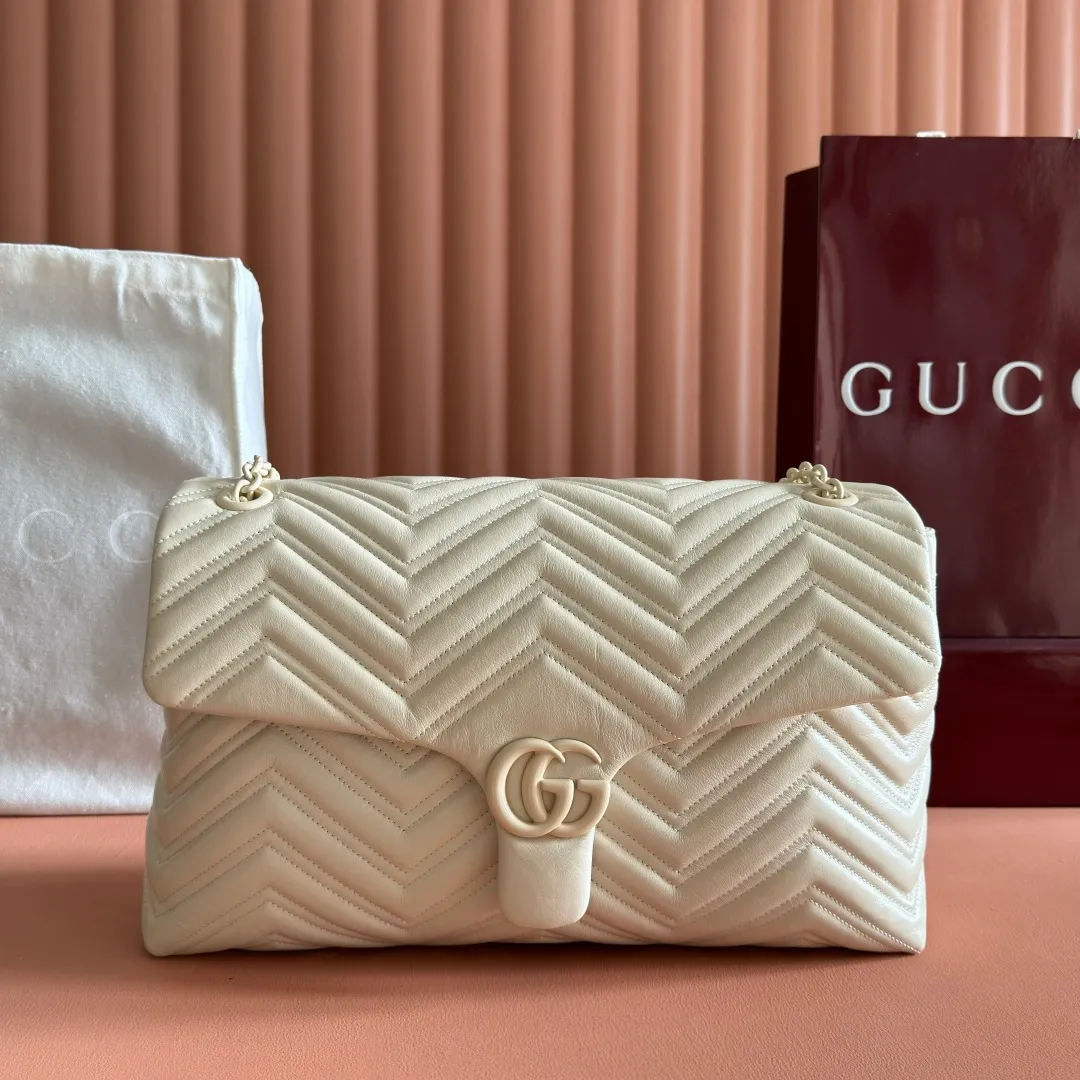 p1960. 💋💋💋【With full set of original counter packaging】2025 autumn and winter series, the brand's iconic GG Marmont series is ingeniously integrated with classic double G elements and faceted chain straps, creating a soft yet crisp silhouette design. This piece is crafted from soft, lightweight quilted V-shaped calfskin leather and features tonal enamel hardware and chain. Black soft lightweight quilted V-shaped calfskin leather. Tonal enamel hardware and chain. Black rayon lining. Double G. Interior: Zippered pocket. Exterior: Back open pocket. Magnetic closure. Ident.: 850659. Dimensions: 37.5cm (W) x 21cm (H) x 9cm (D) Color: White/Soft Leather. Made in Italy